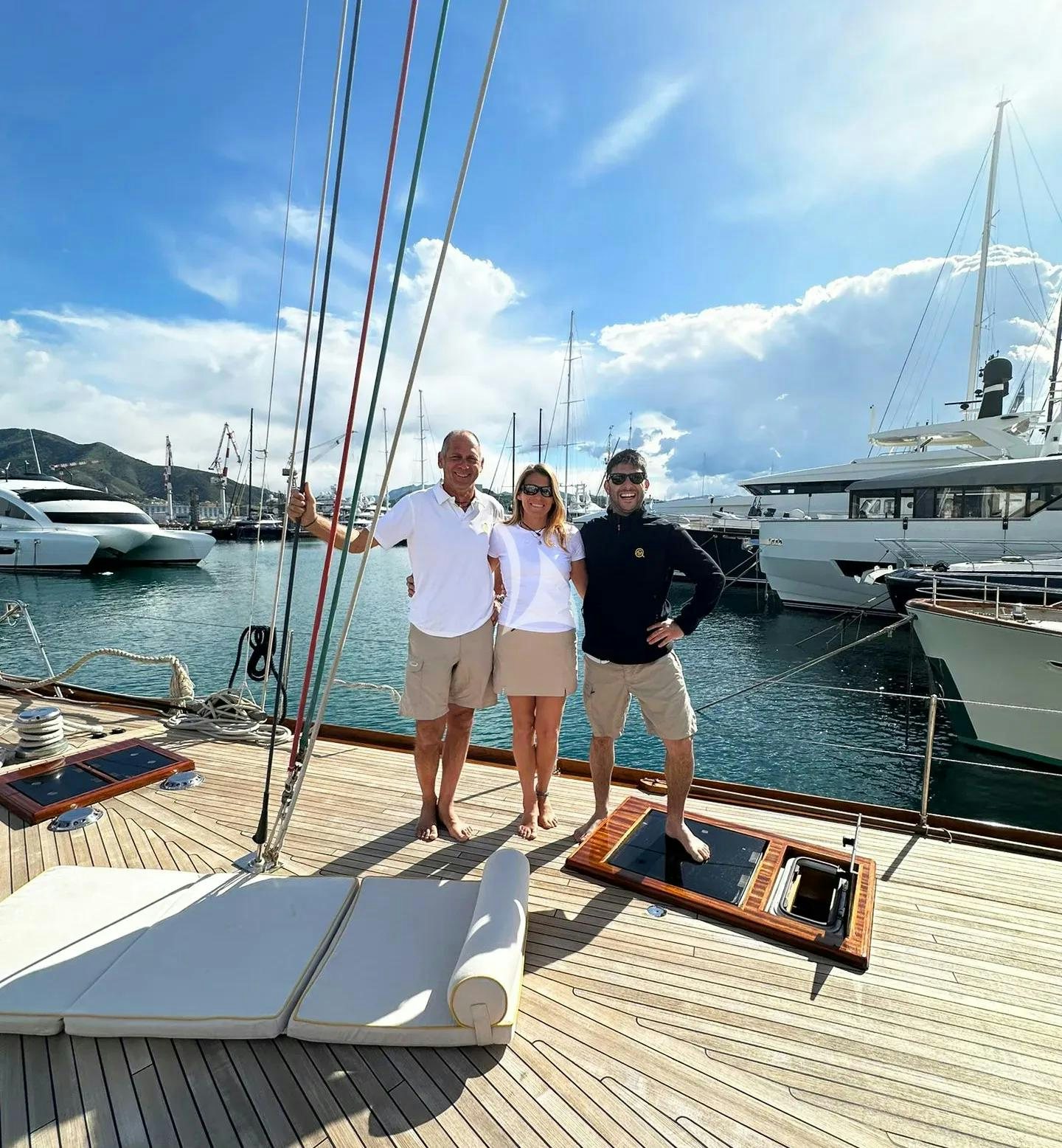 a group of people posing for a picture on a dock aboard QUARTA SANTA MARIA Yacht for Sale