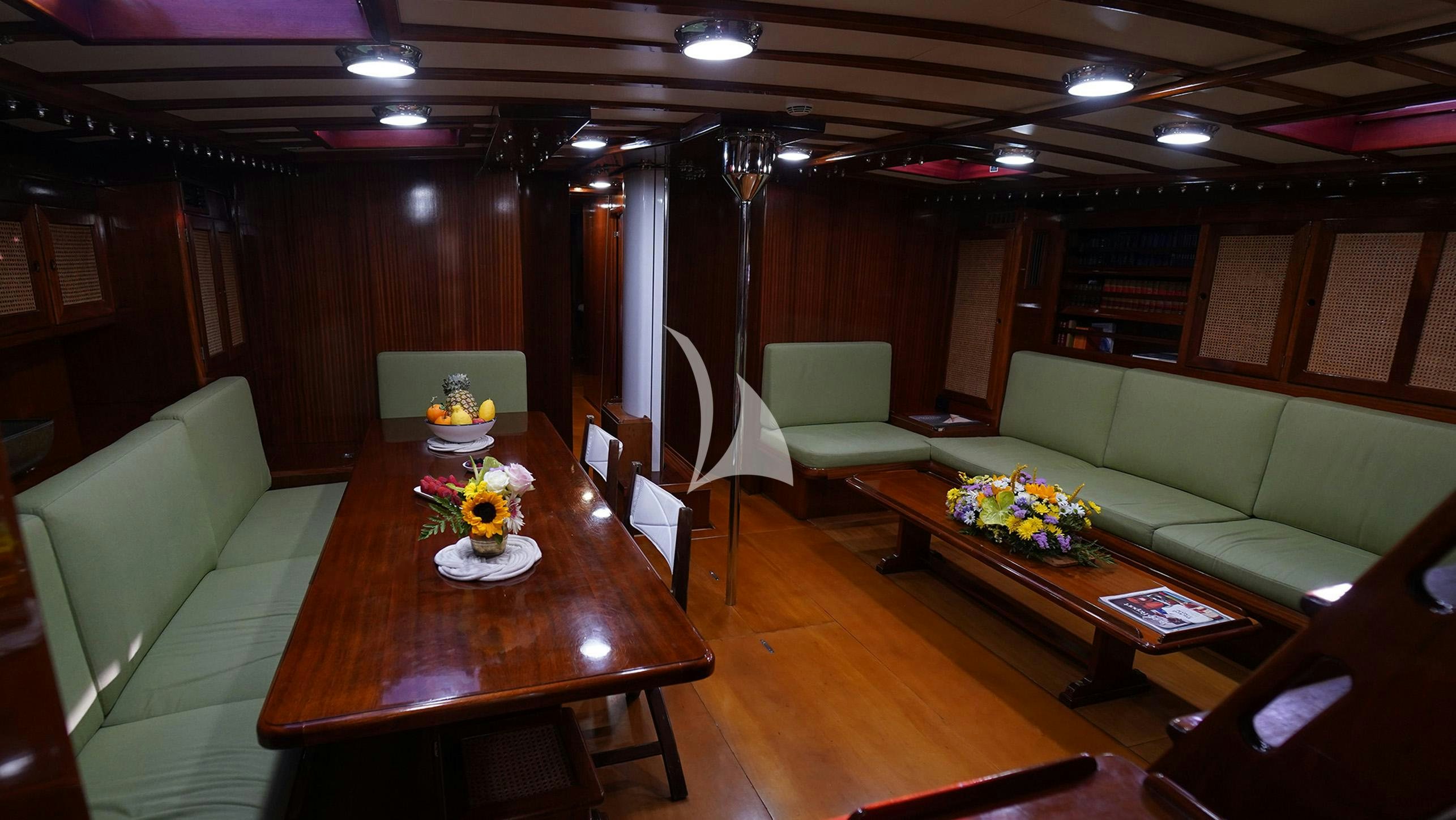 a living room with a couch and a table aboard QUARTA SANTA MARIA Yacht for Sale
