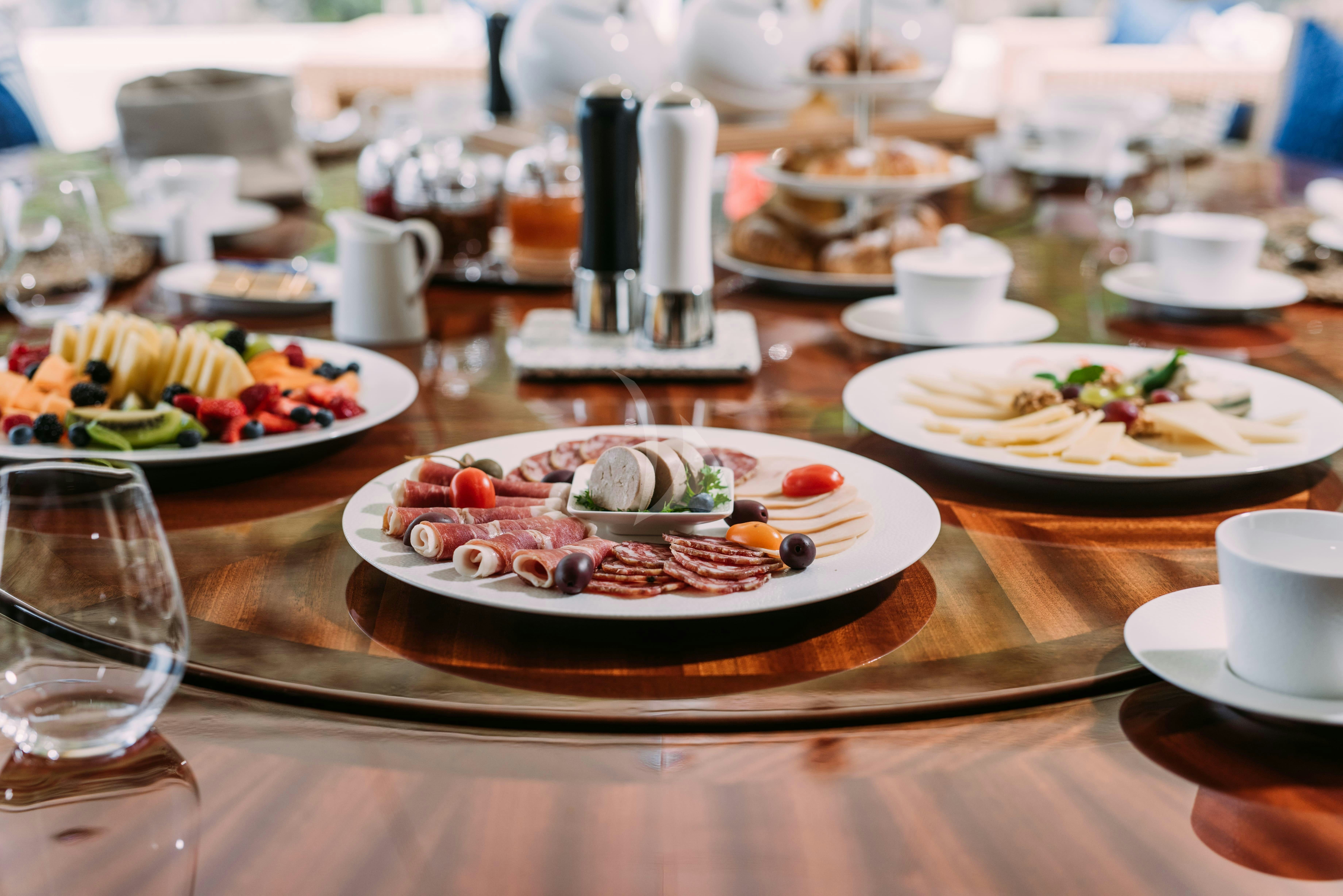 a table with plates of food and glasses on it aboard TIREA Yacht for Charter
