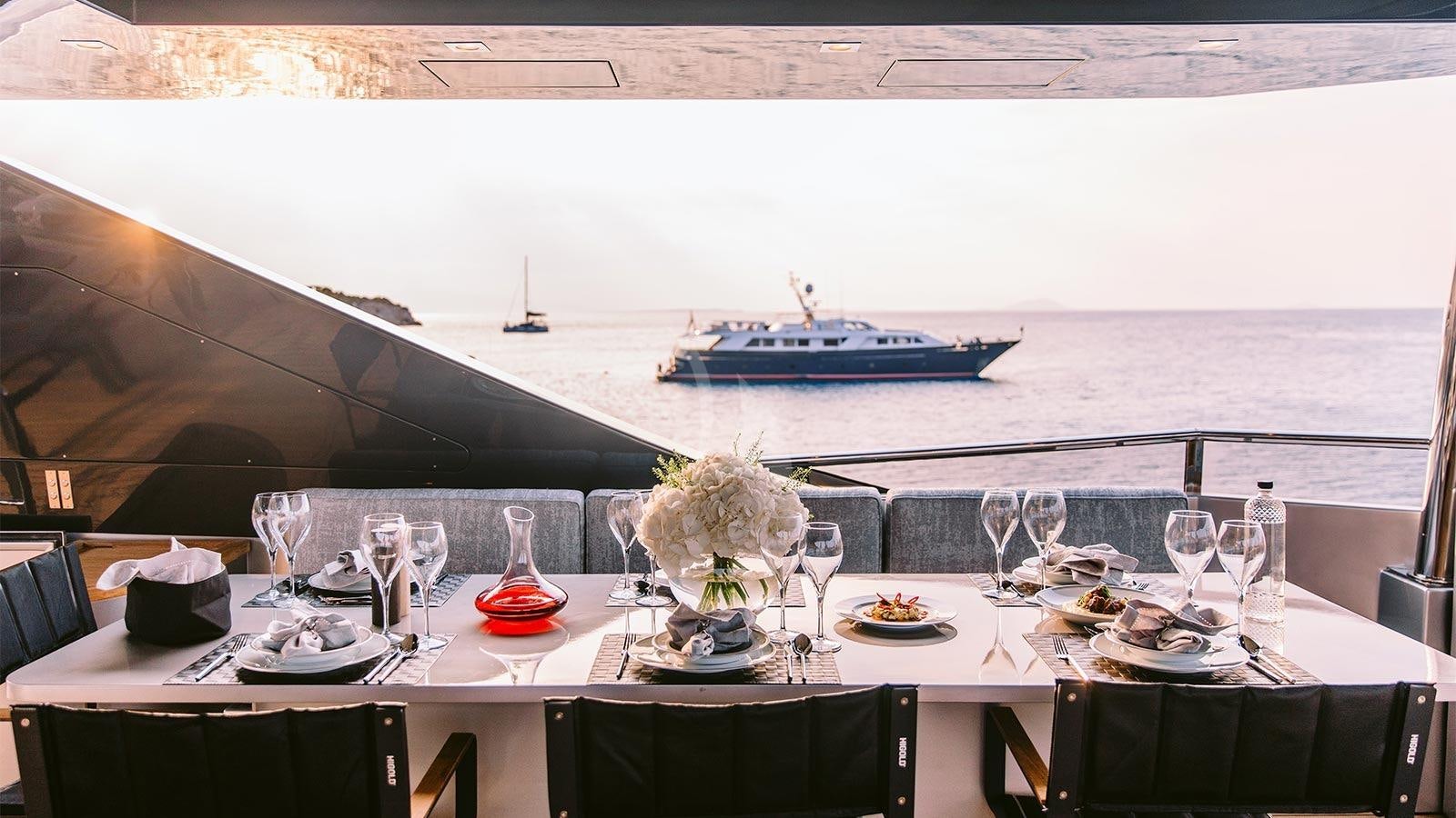a table with food and glasses on it aboard OVAL Yacht for Charter