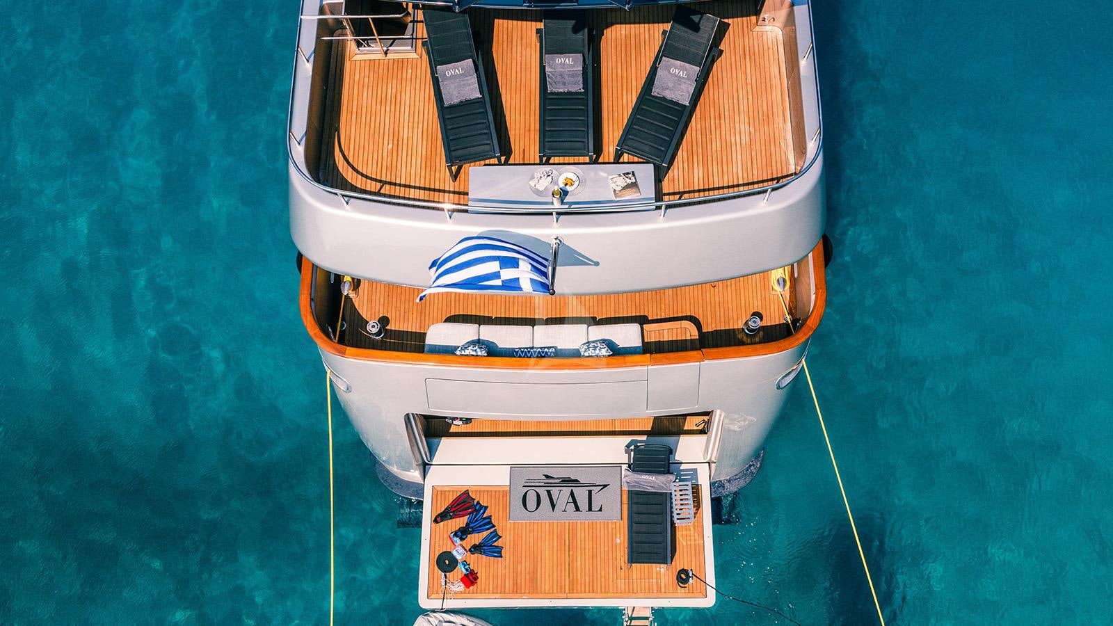 a boat with a flag on it aboard OVAL Yacht for Charter