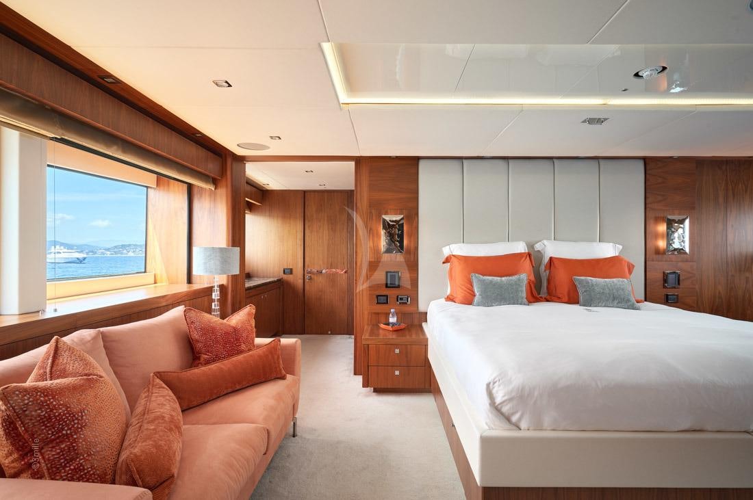 a bedroom with a bed and a couch aboard EVEREAST Yacht for Charter