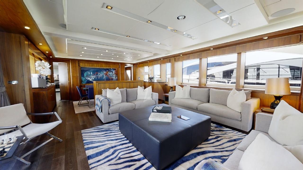 a large living room with a large blue rug aboard EVEREAST Yacht for Charter