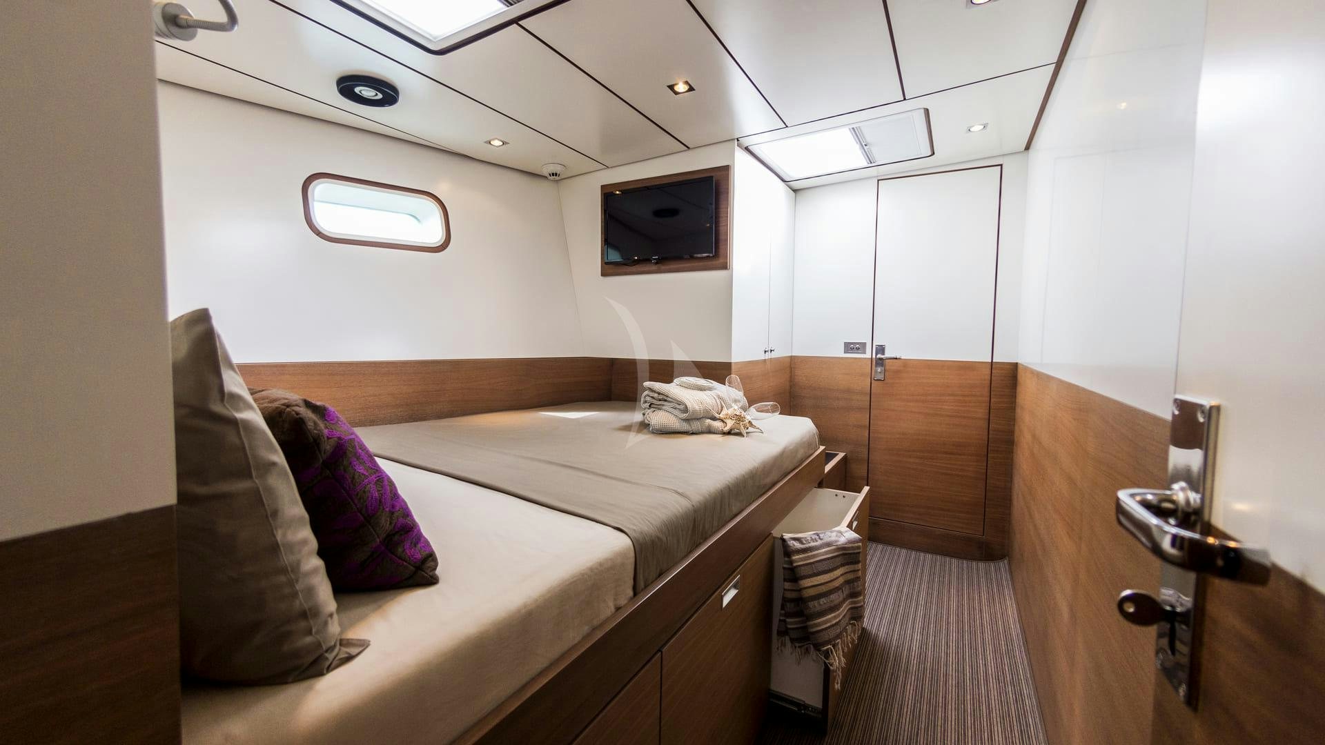 a room with a bed and a tv on the wall aboard AIZU Yacht for Sale