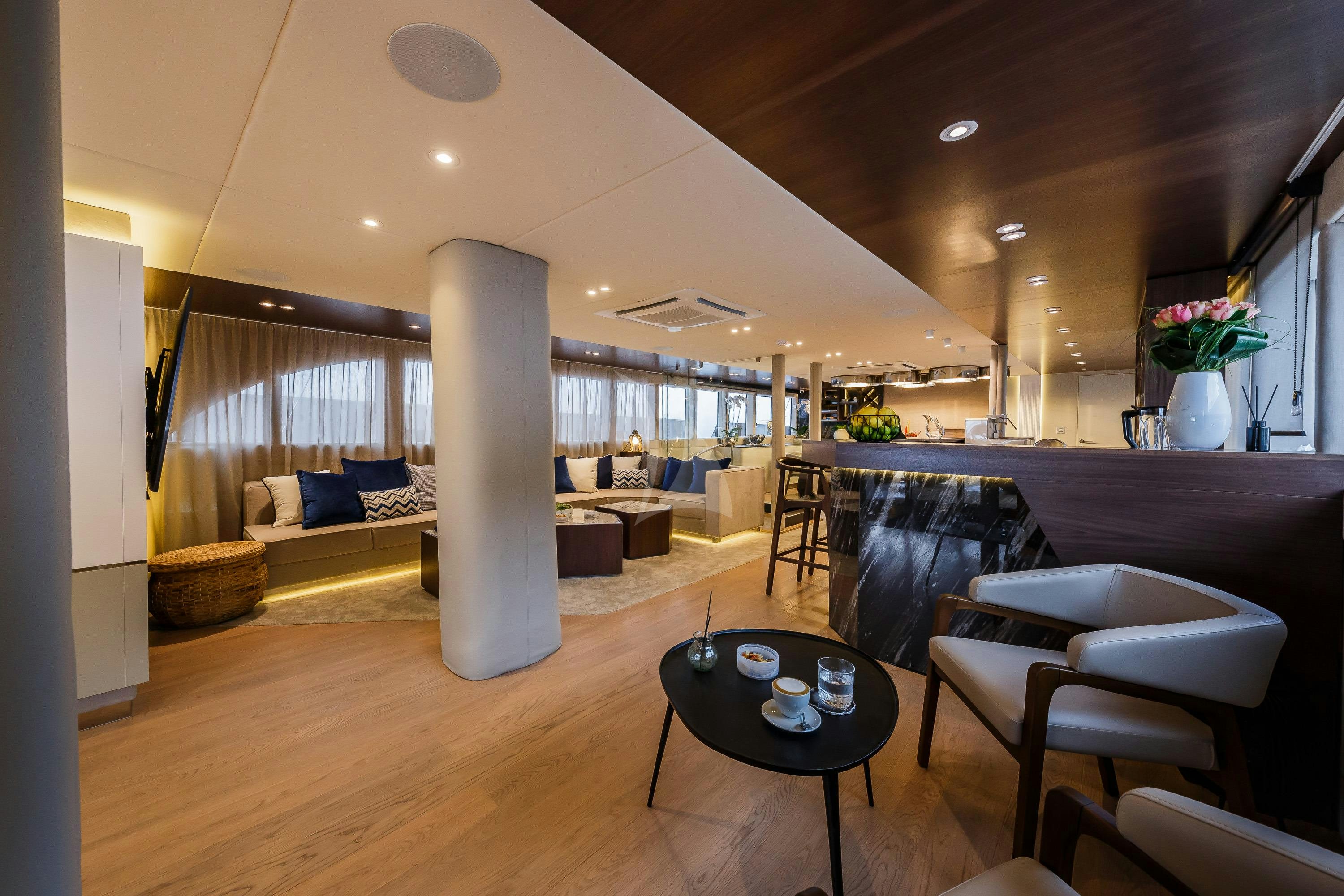 a living room with a large white pillar and a table aboard CLASE AZUL Yacht for Charter