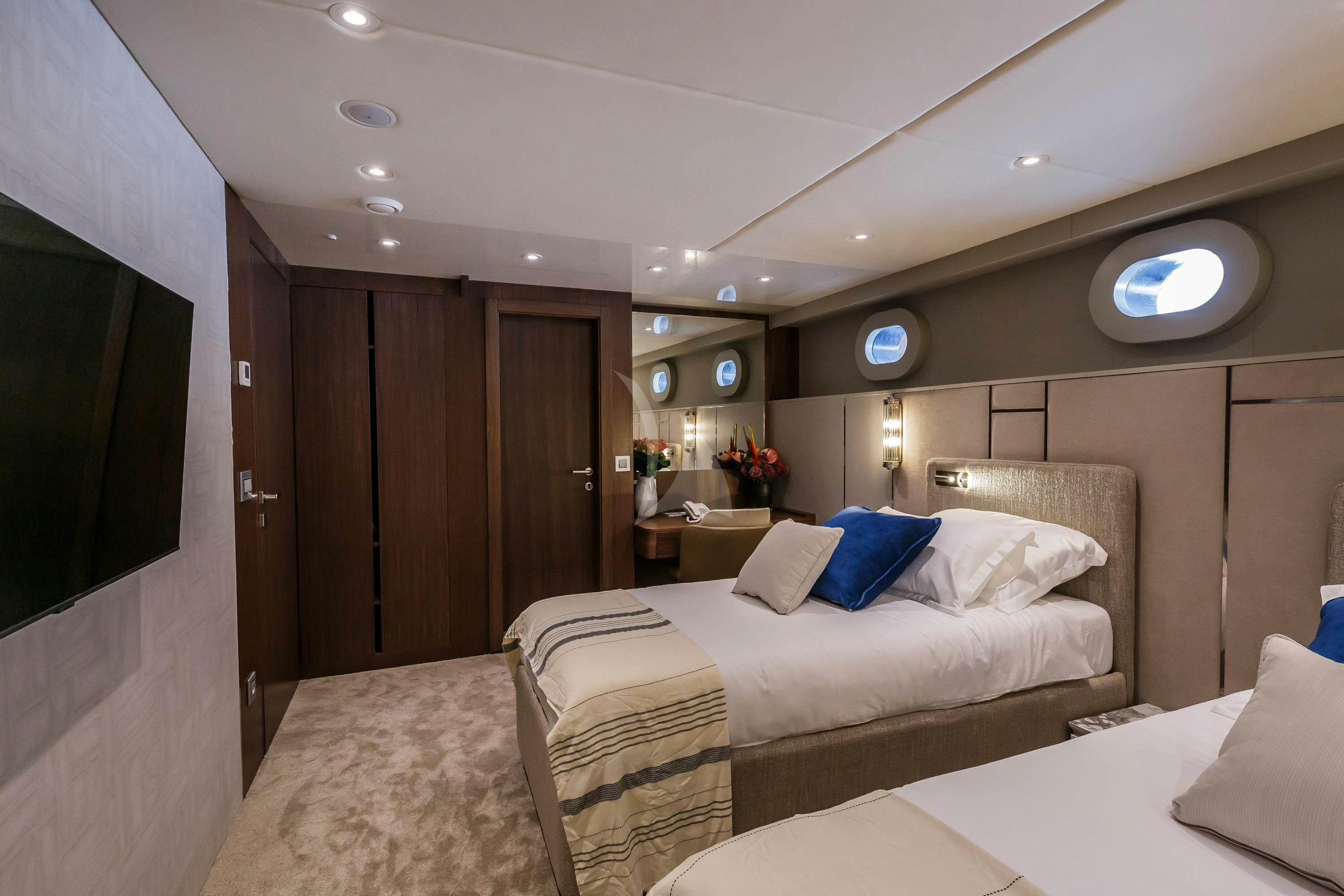 a room with a bed and a television aboard CLASE AZUL Yacht for Charter
