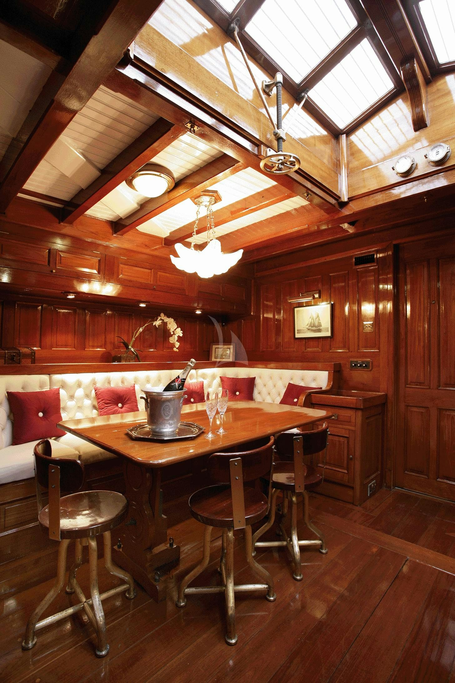 a wooden cabin with a table and chairs aboard AELLO Yacht for Charter