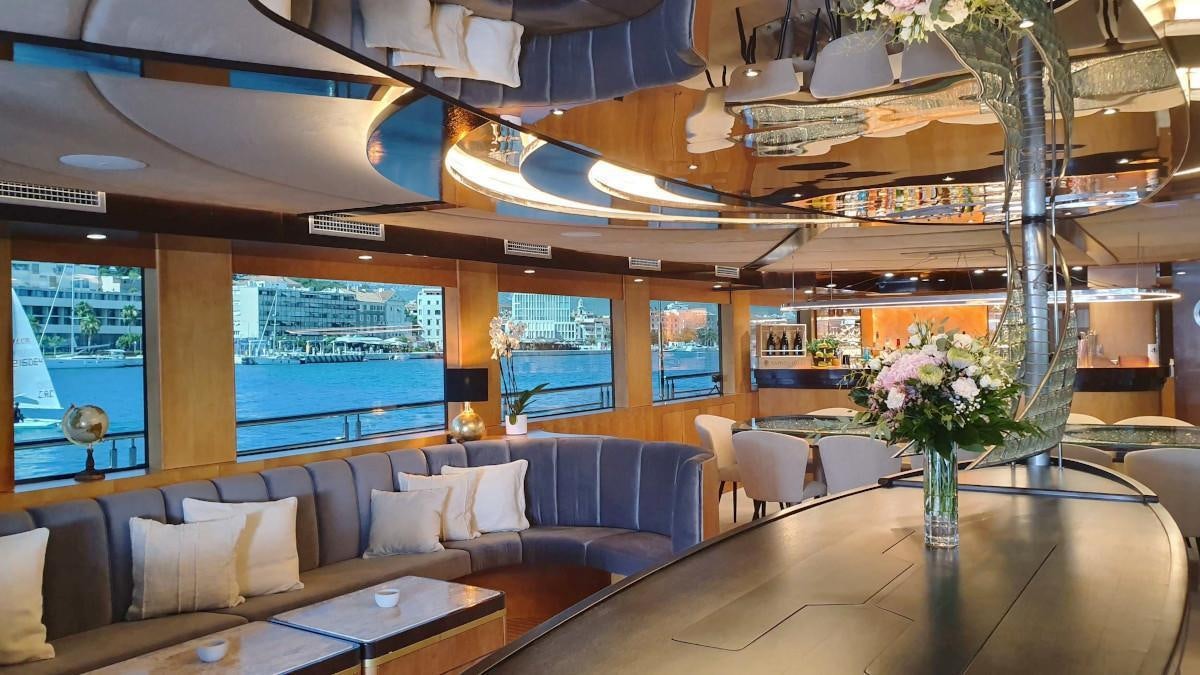 a large room with a table and couches aboard LIFE IS GOOD Yacht for Charter