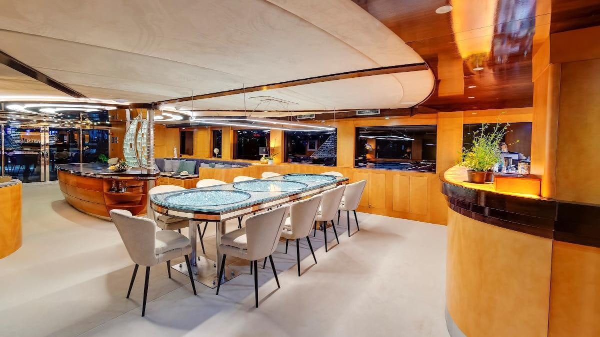 a room with tables and chairs aboard LIFE IS GOOD Yacht for Charter