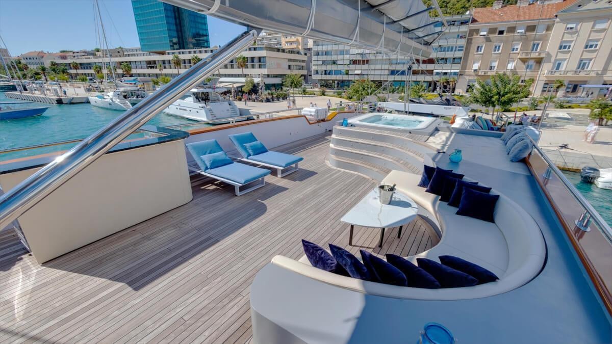 a deck with a table and chairs on it aboard LIFE IS GOOD Yacht for Charter