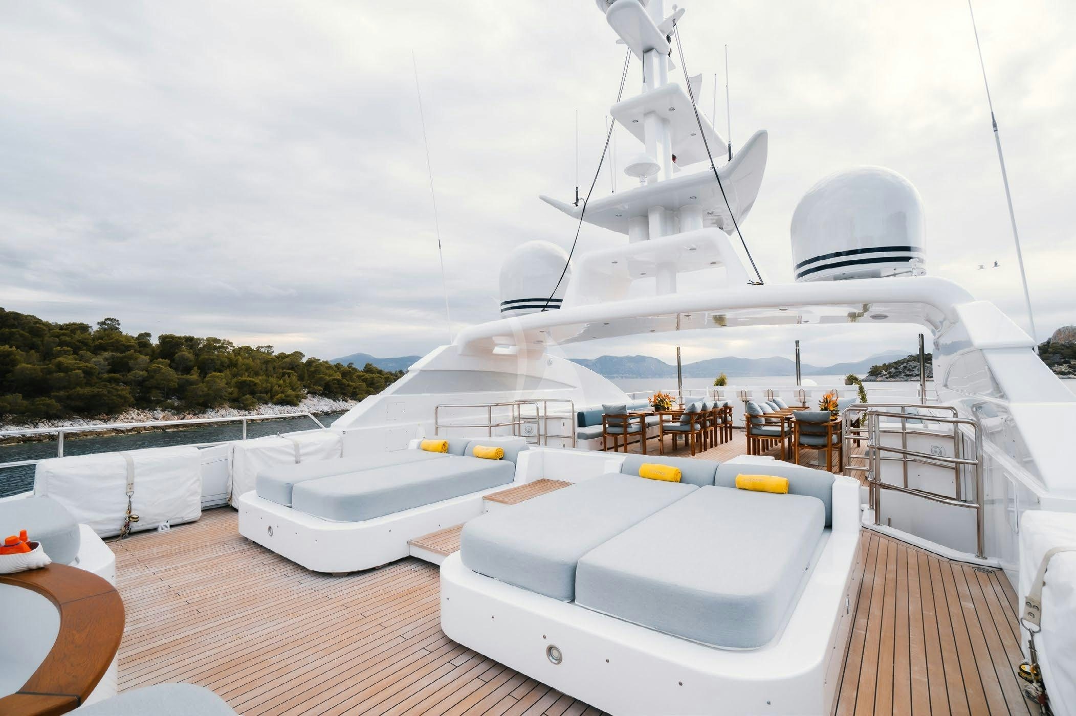 a deck with a large white boat on it aboard OCEANOS Yacht for Charter