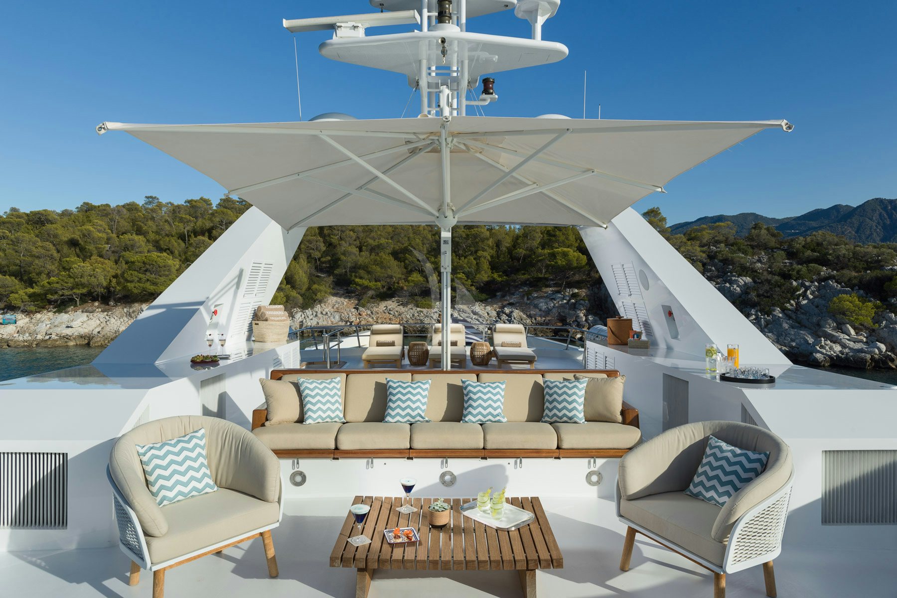 a lounge area with a large white tent and a table with chairs and a white chair and a aboard KASSANDRA Yacht for Charter