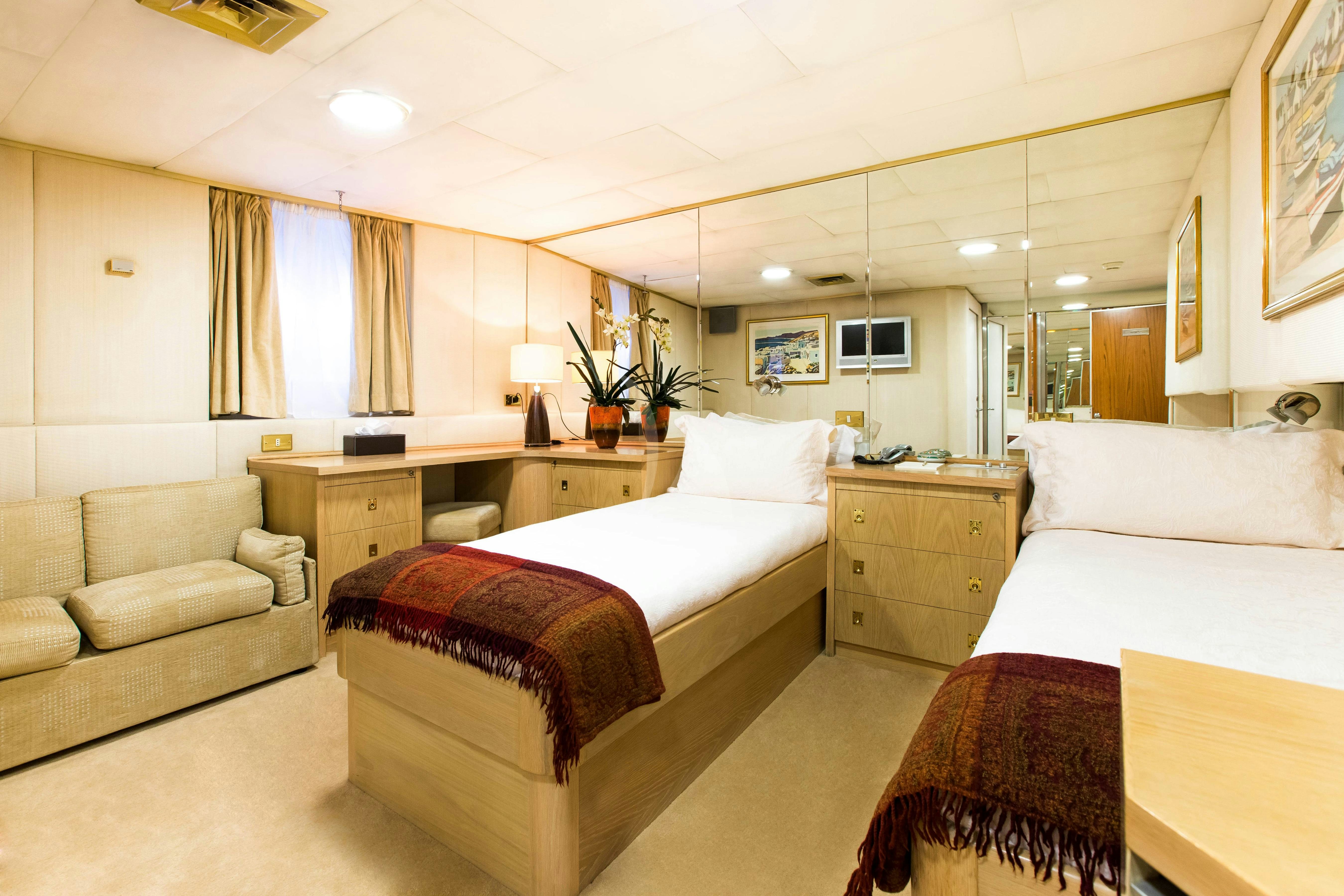 a room with two beds and a couch aboard ESMERALDA Yacht for Charter