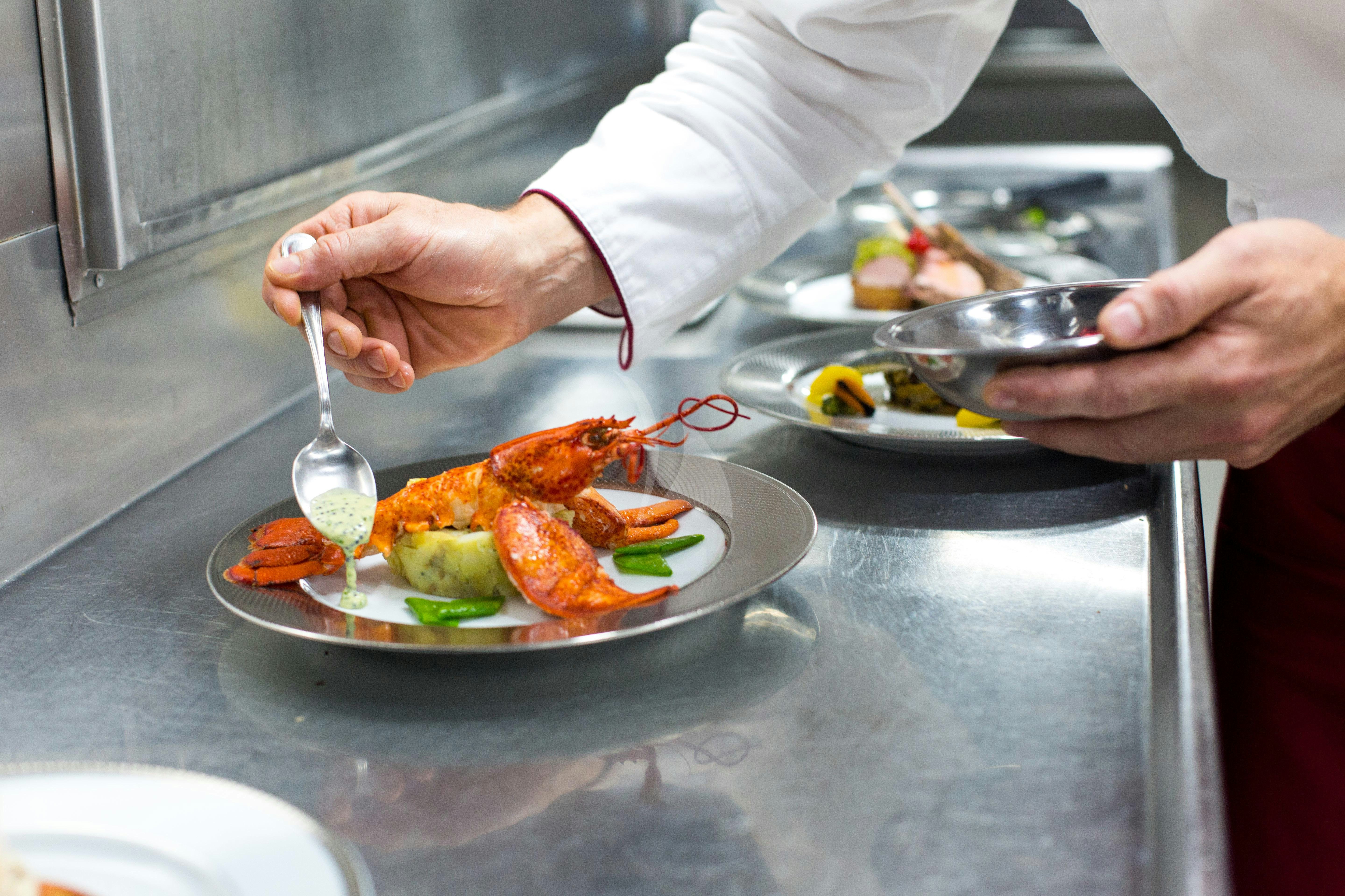 a person preparing food on a plate aboard ESMERALDA Yacht for Charter