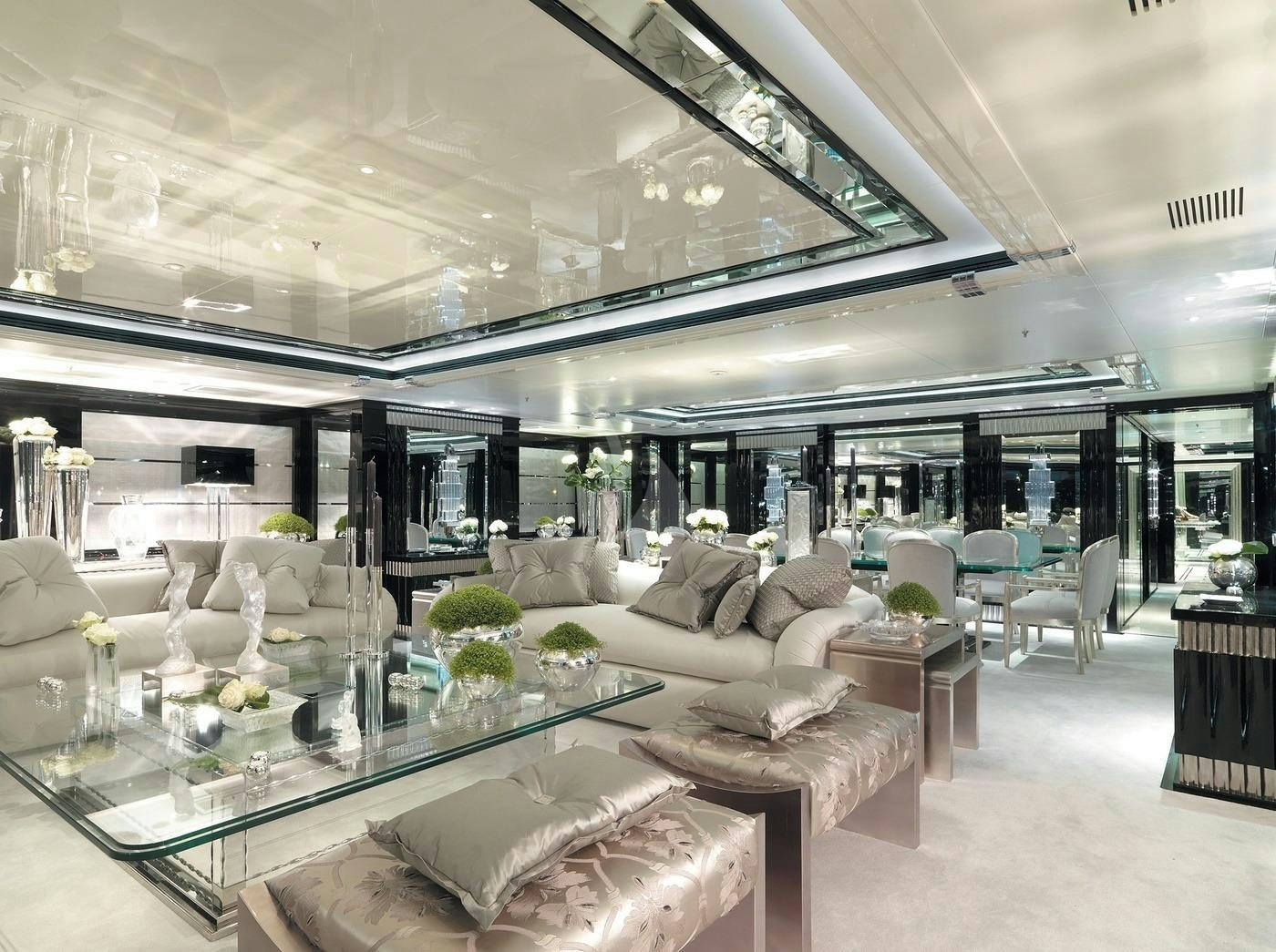 a large living room with a large glass table and chairs aboard SILVER ANGEL Yacht for Charter