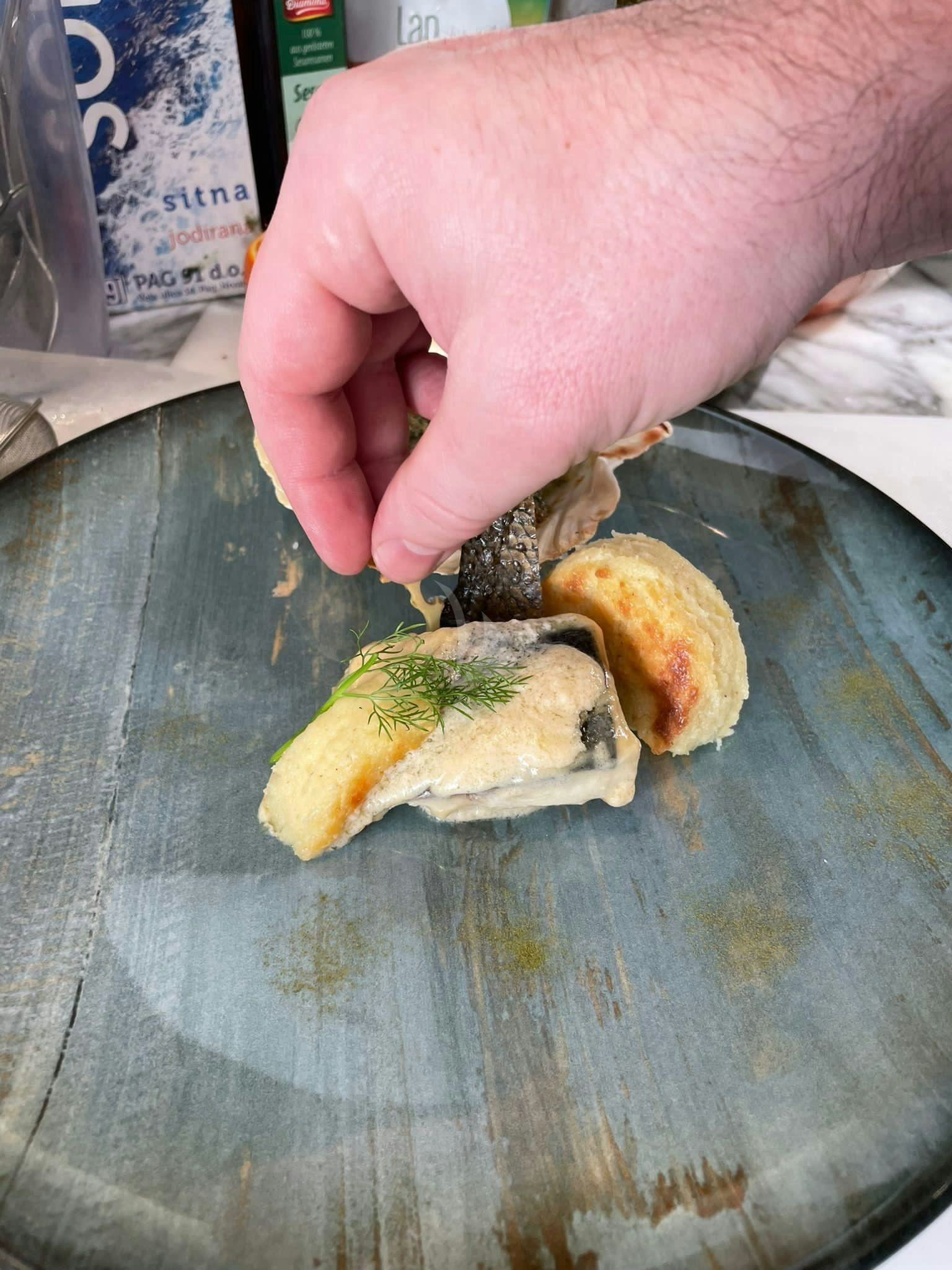 a hand holding a piece of food aboard ANAVI Yacht for Charter