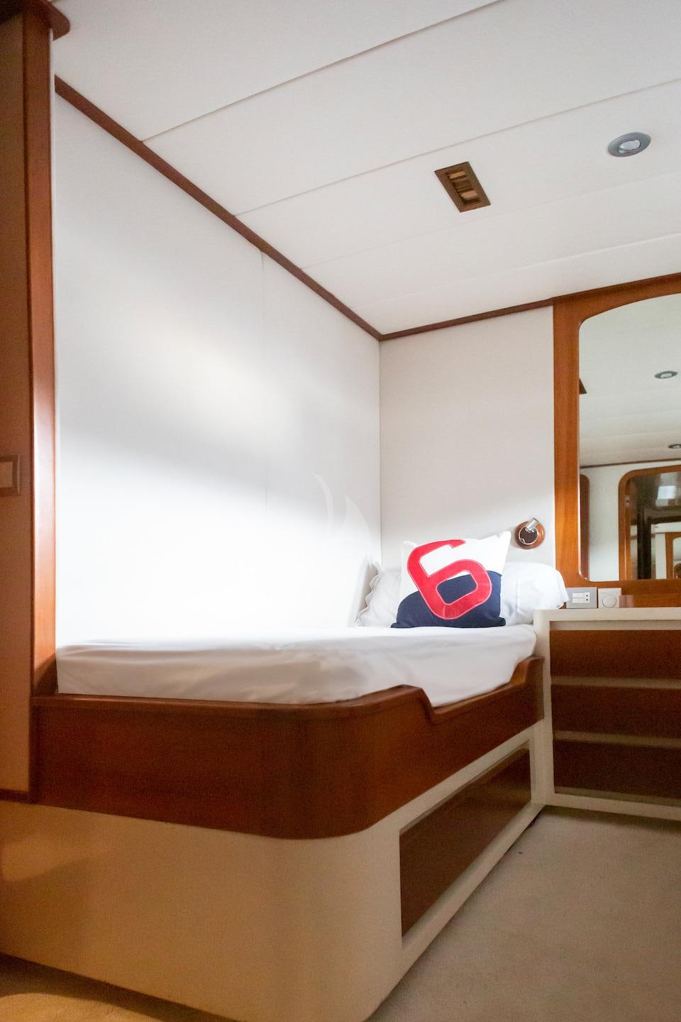 a bed with a red pillow aboard SPIRIT OF MK Yacht for Charter