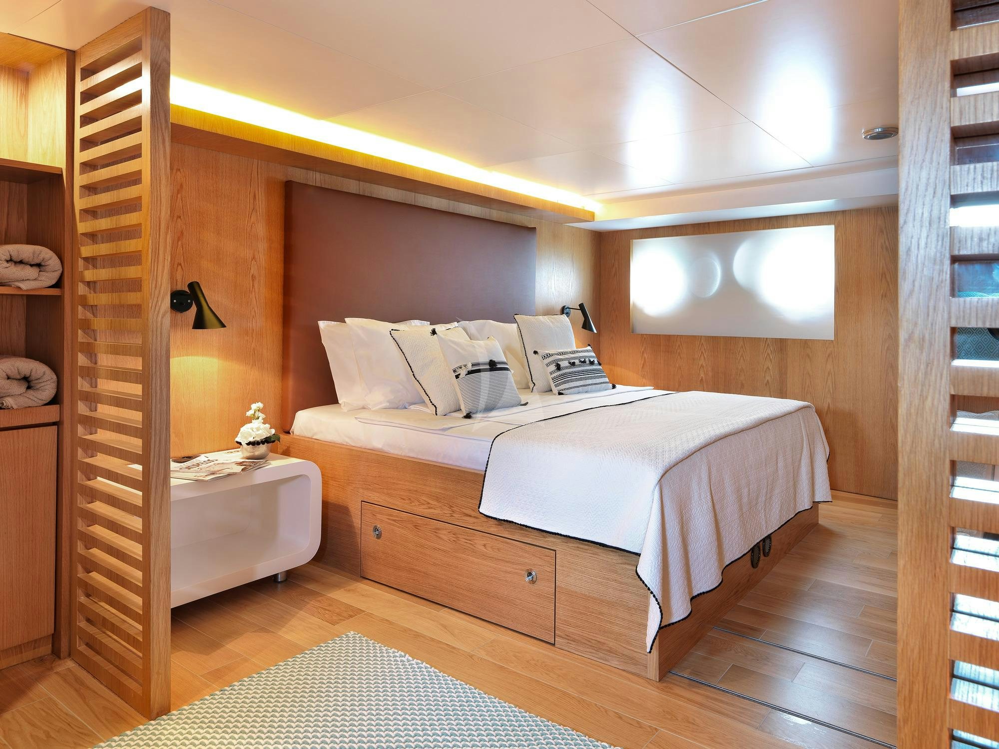 a bedroom with a bed and a wood door aboard SOUNION II Yacht for Charter