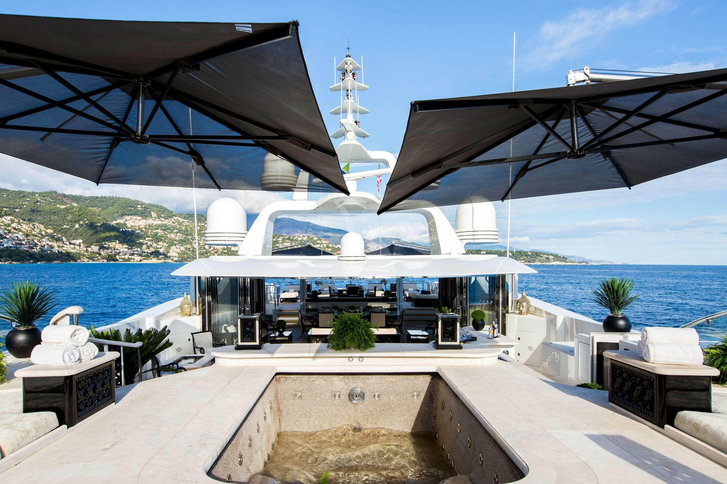 a patio with a large white building and a large body of water aboard LIONESS V Yacht for Charter