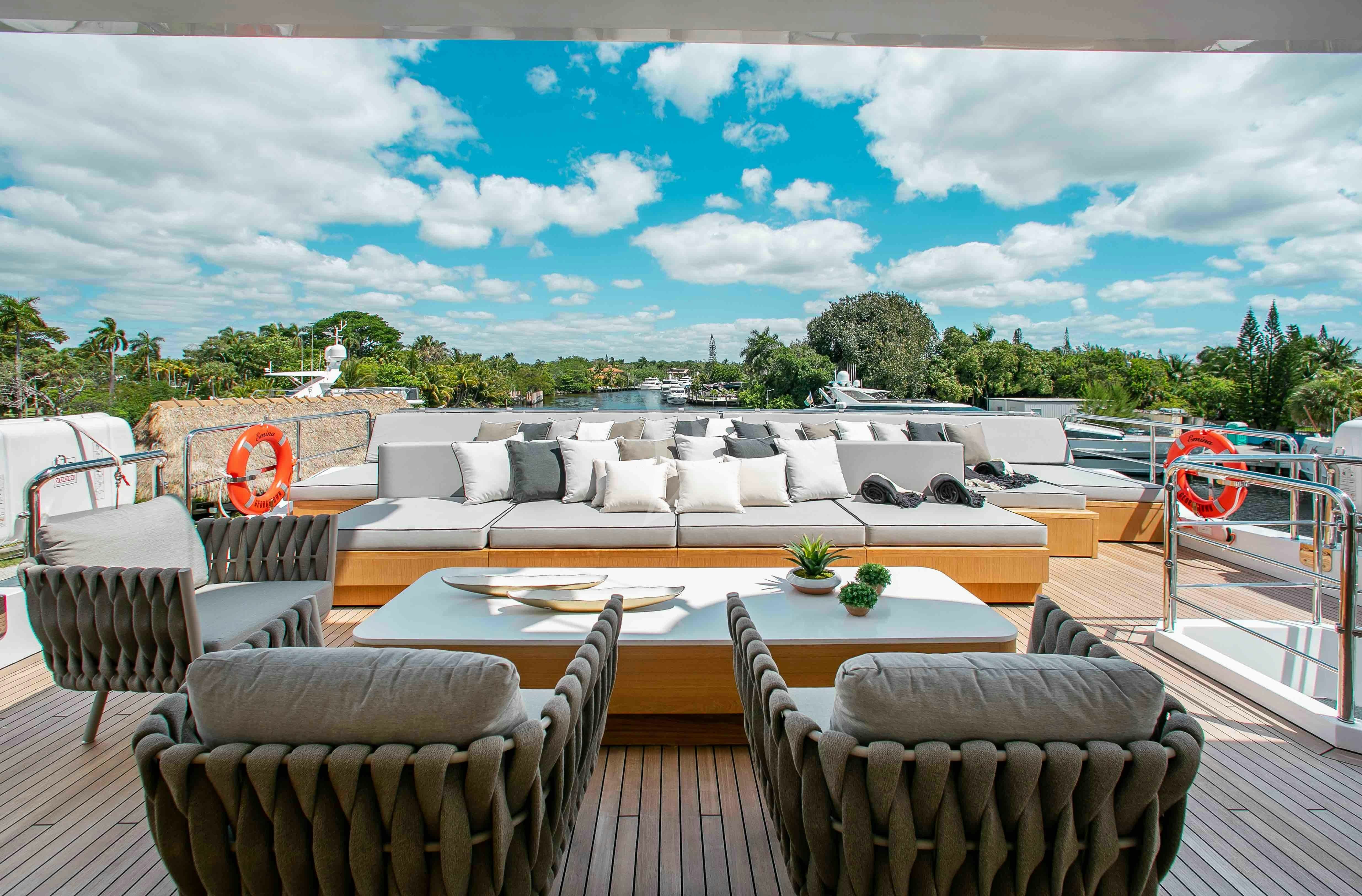 a large pool with a table and chairs on a deck aboard EMINA Yacht for Charter