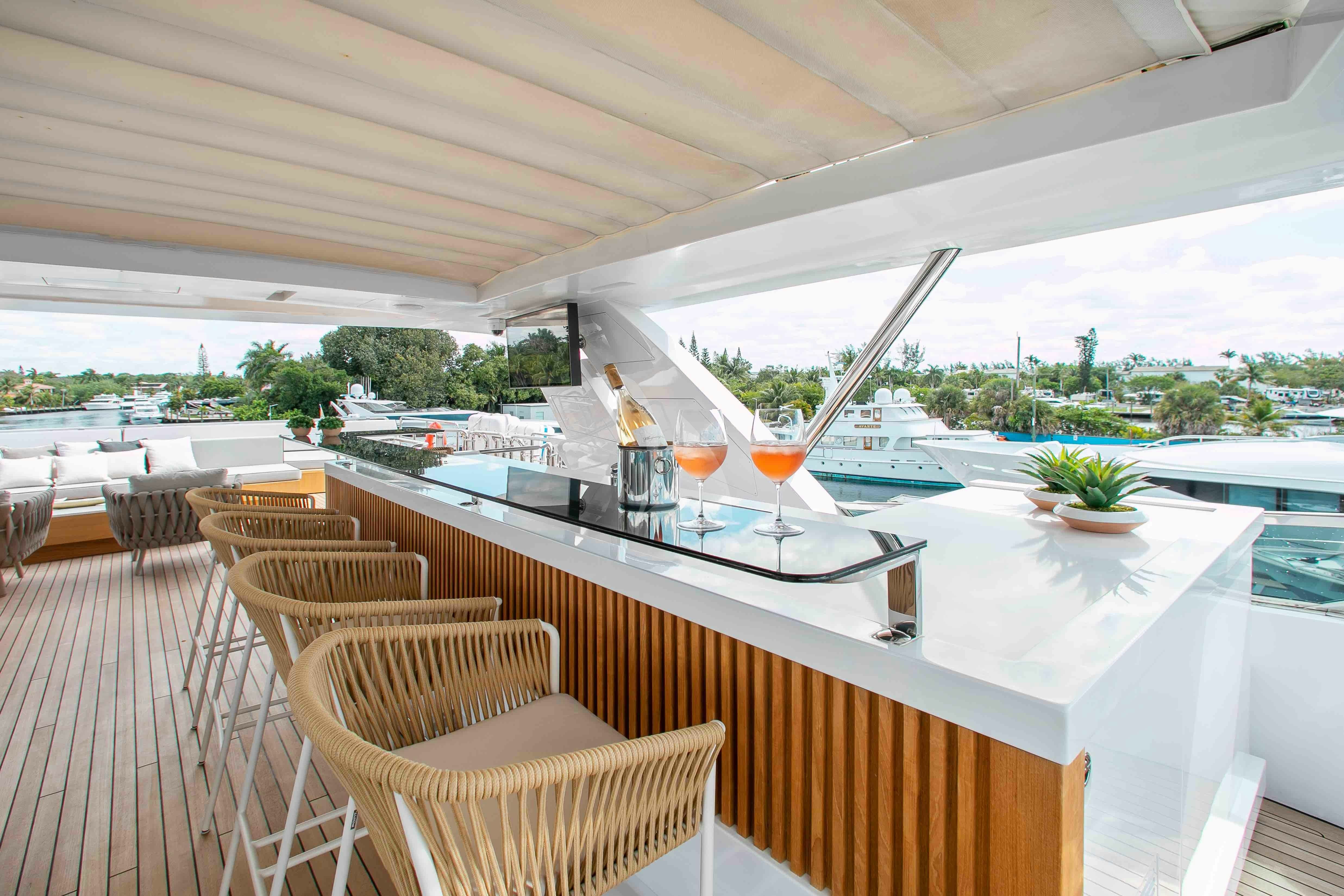 a large open area with a table and chairs and a large window aboard EMINA Yacht for Charter