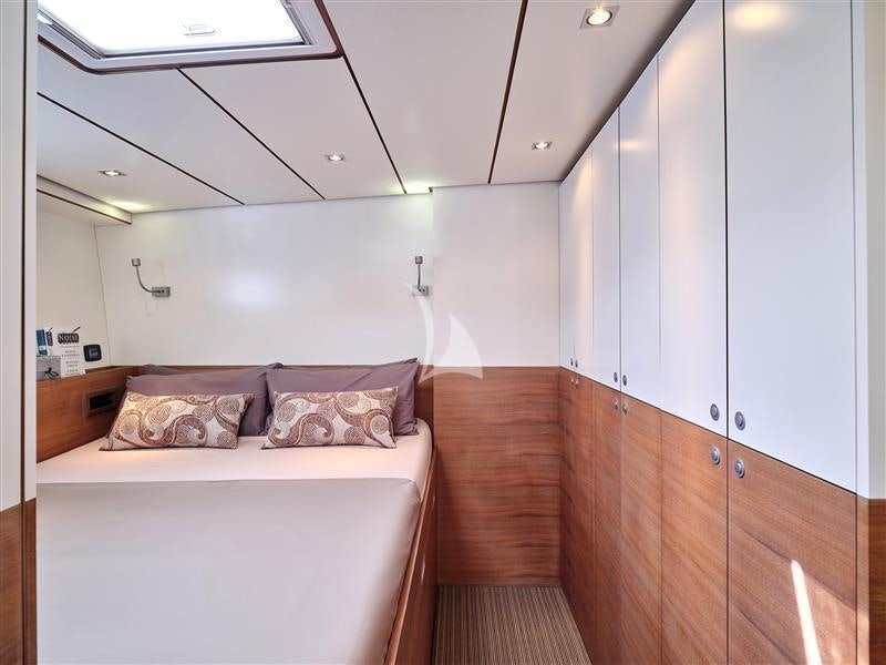 a bedroom with a bed and a wood floor aboard AIZU Yacht for Sale