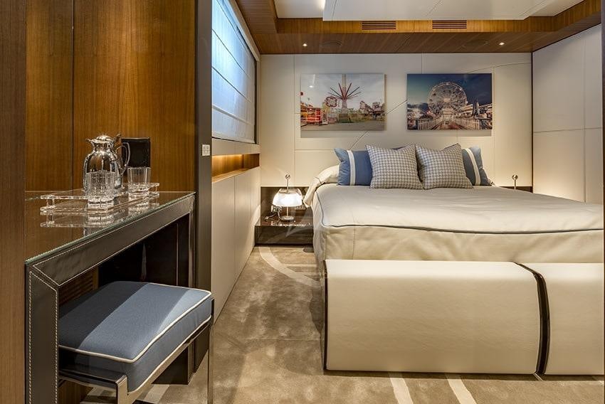 a room with a bed and a coffee table aboard TALEYA Yacht for Charter