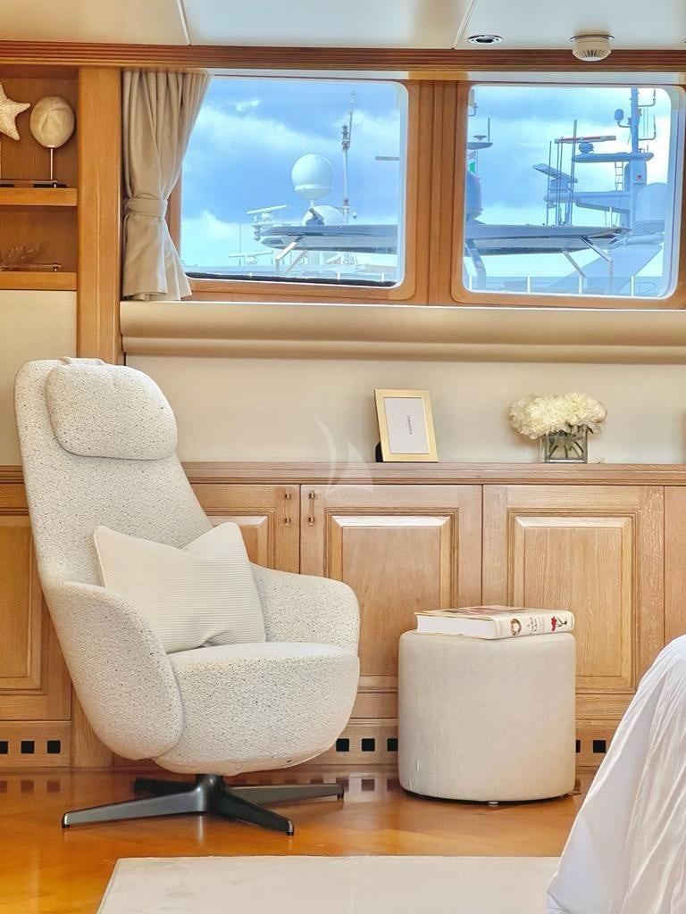 a room with a chair and a window aboard SOLAFIDE Yacht for Charter