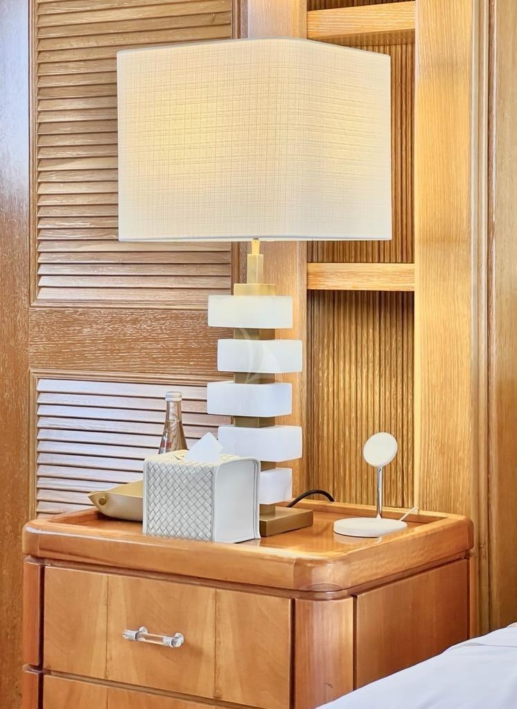 a desk with a lamp and a book on it aboard SOLAFIDE Yacht for Charter