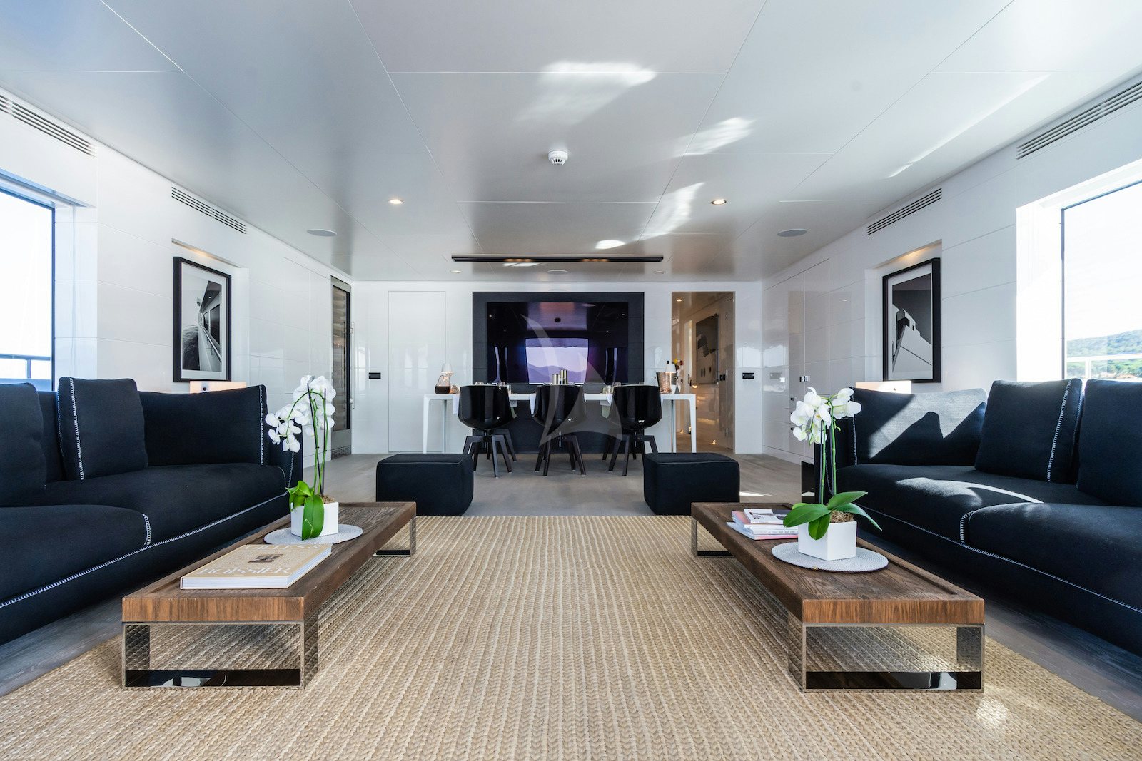 a living room with a black couch and a coffee table aboard S7 Yacht for Charter
