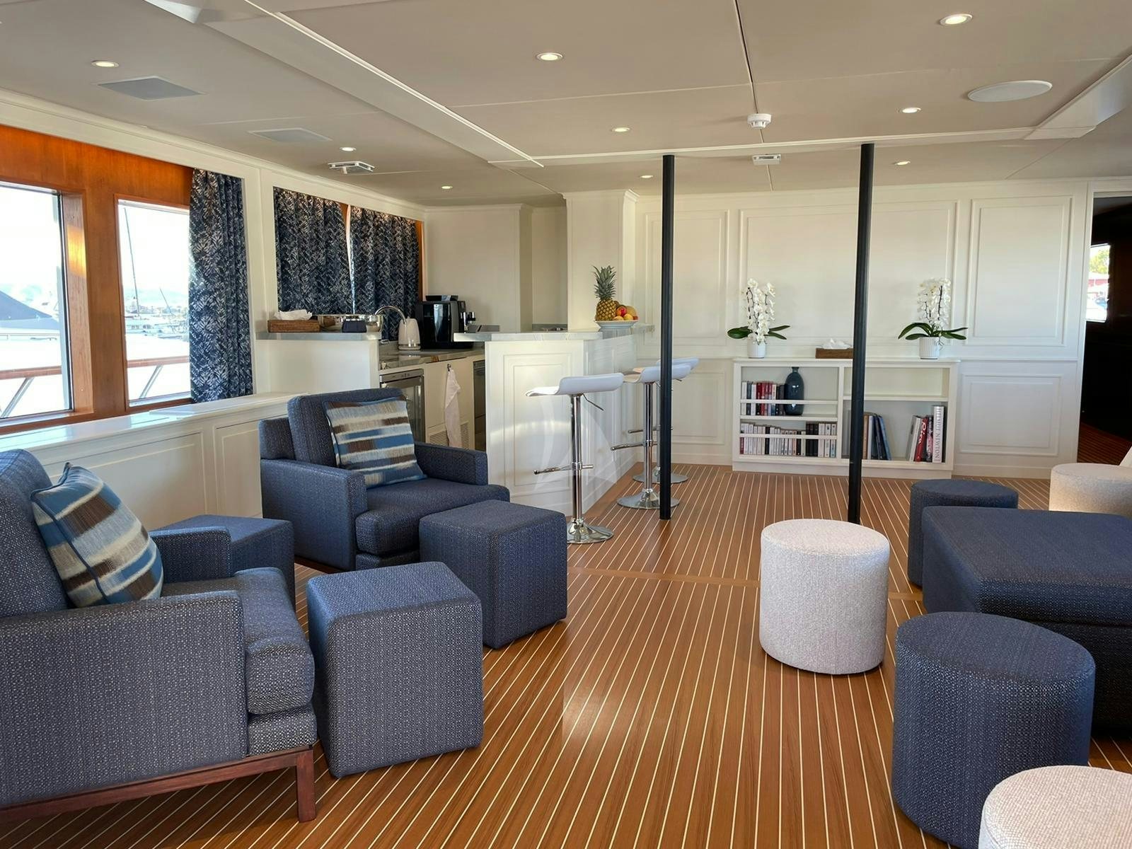 a large living room with a wood floor aboard GENESIA Yacht for Charter