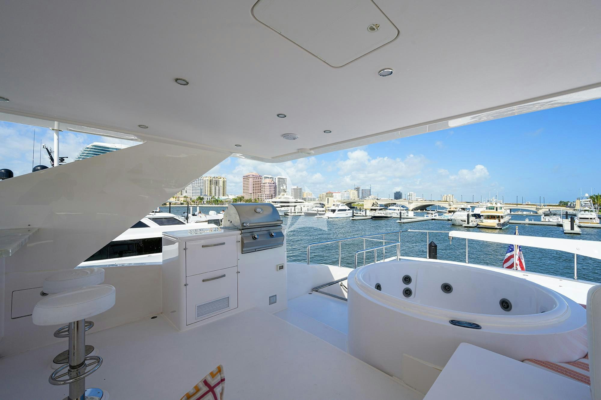 a large white bathtub in a room with a large window and a view of the city aboard RISK TAKER Yacht for Charter
