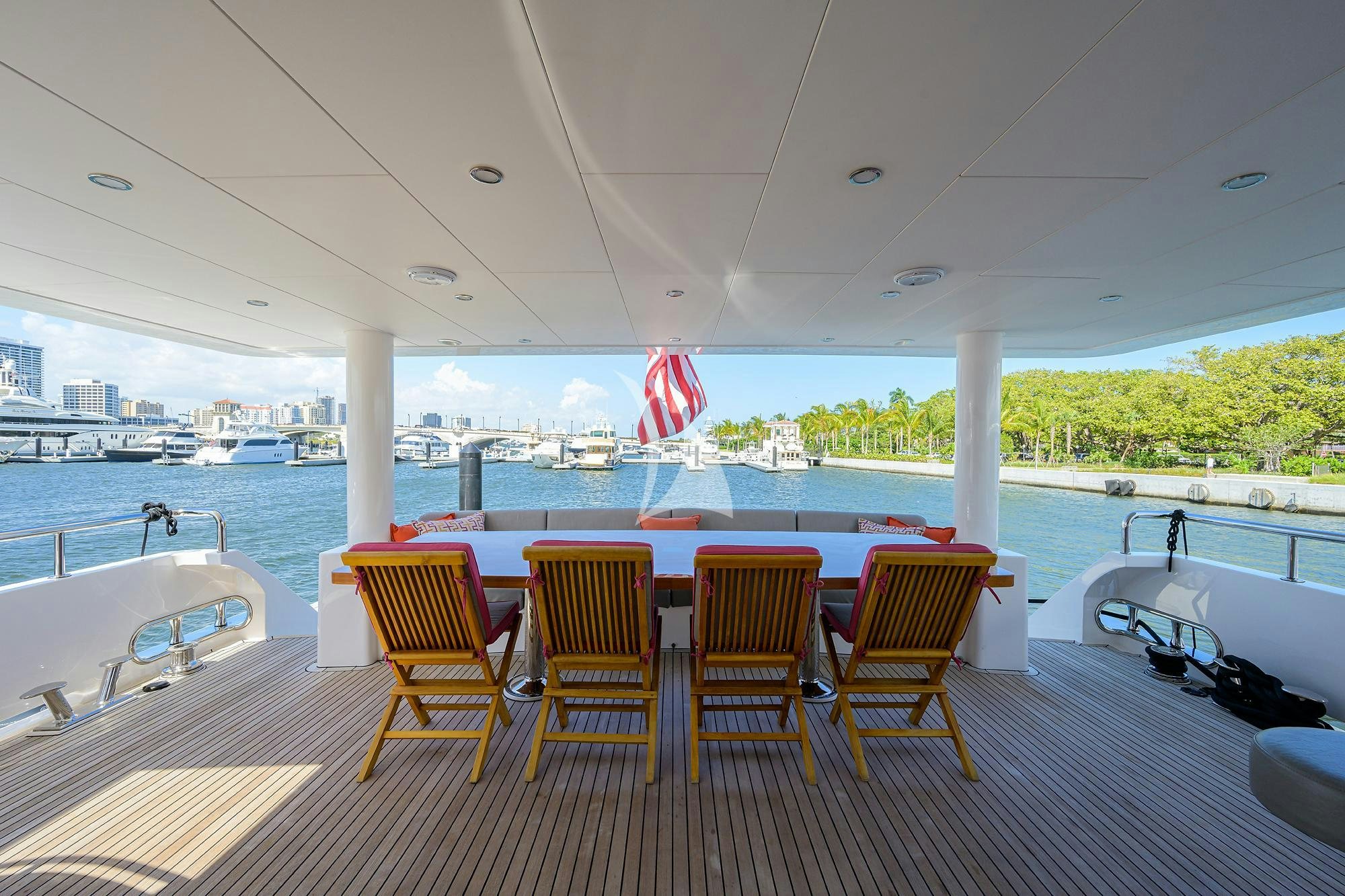 a deck with chairs and a flag aboard RISK TAKER Yacht for Charter