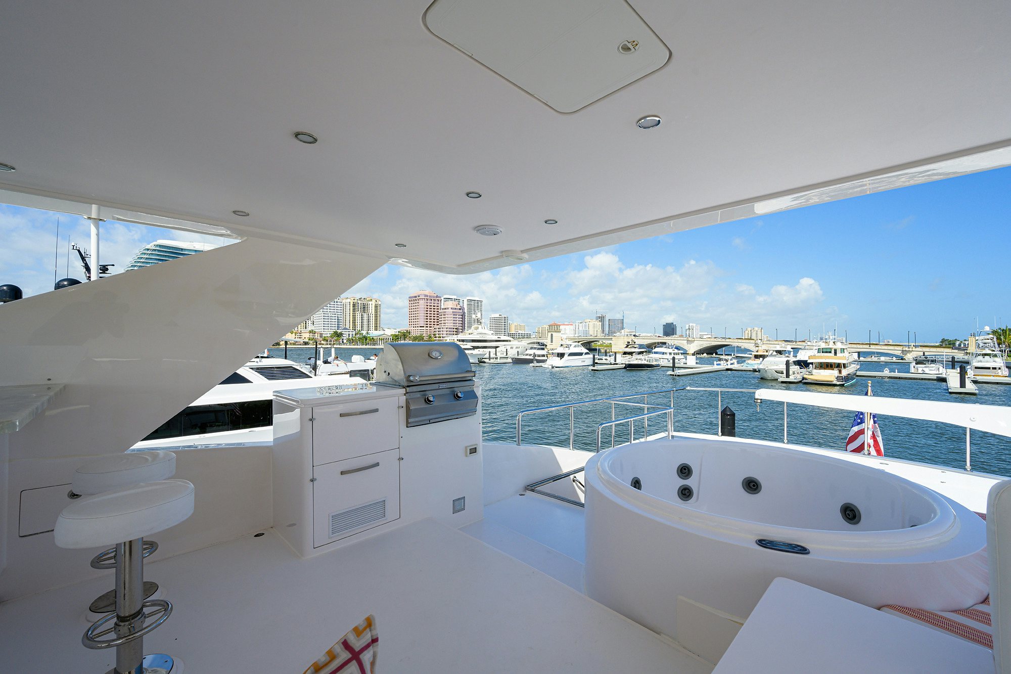 a large white bathtub in a room with a large window and a view of the city aboard RISK TAKER Yacht for Charter