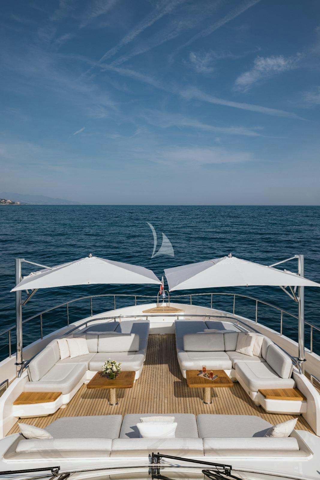 a deck with chairs and tables on it by the water aboard RIVIERA LIVING Yacht for Charter
