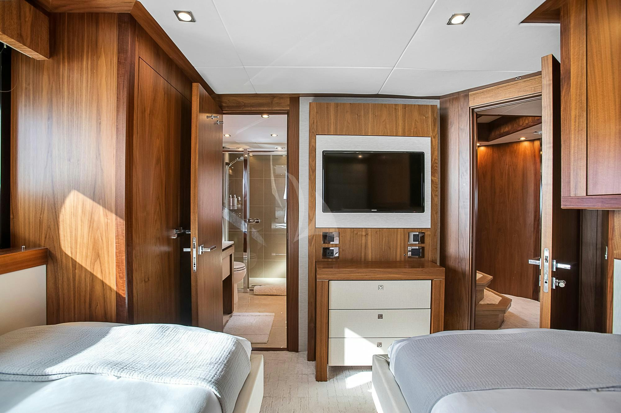 a bedroom with a bed and a television aboard EVEREAST Yacht for Charter
