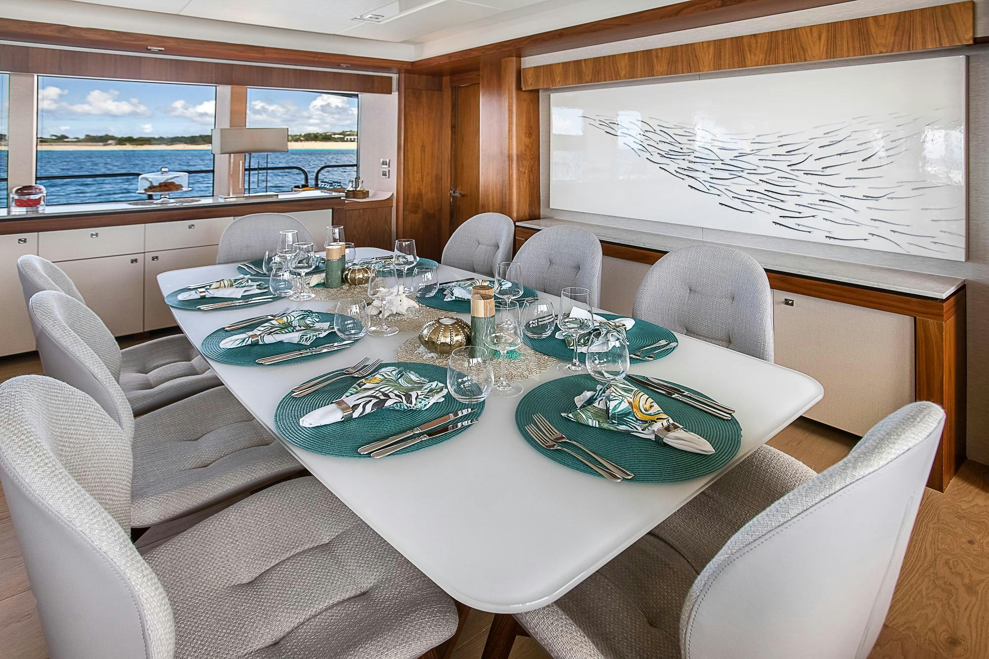 a dining table with plates and glasses aboard EVEREAST Yacht for Charter