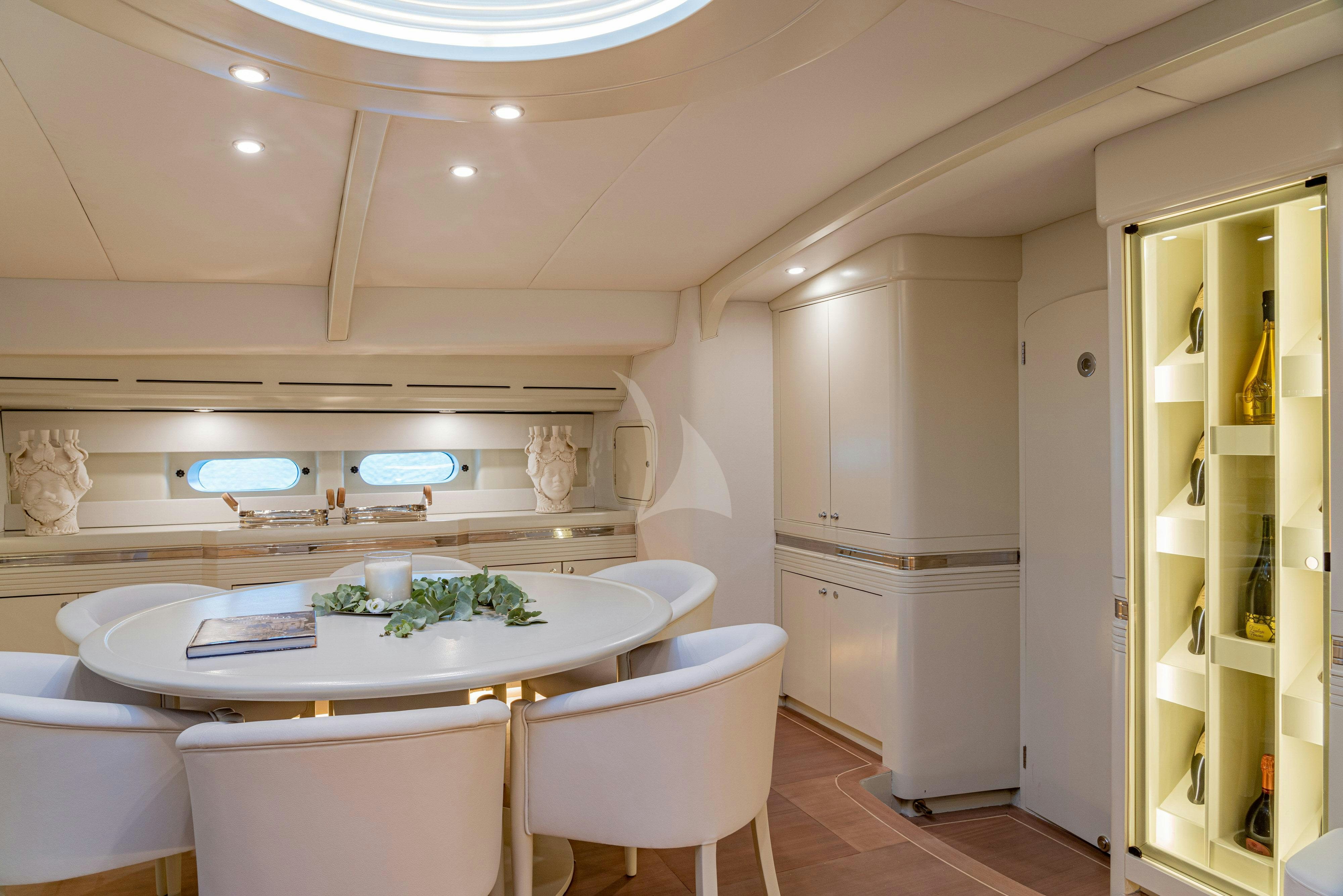 a kitchen with a table and chairs aboard ASHLEYROSE110 Yacht for Charter