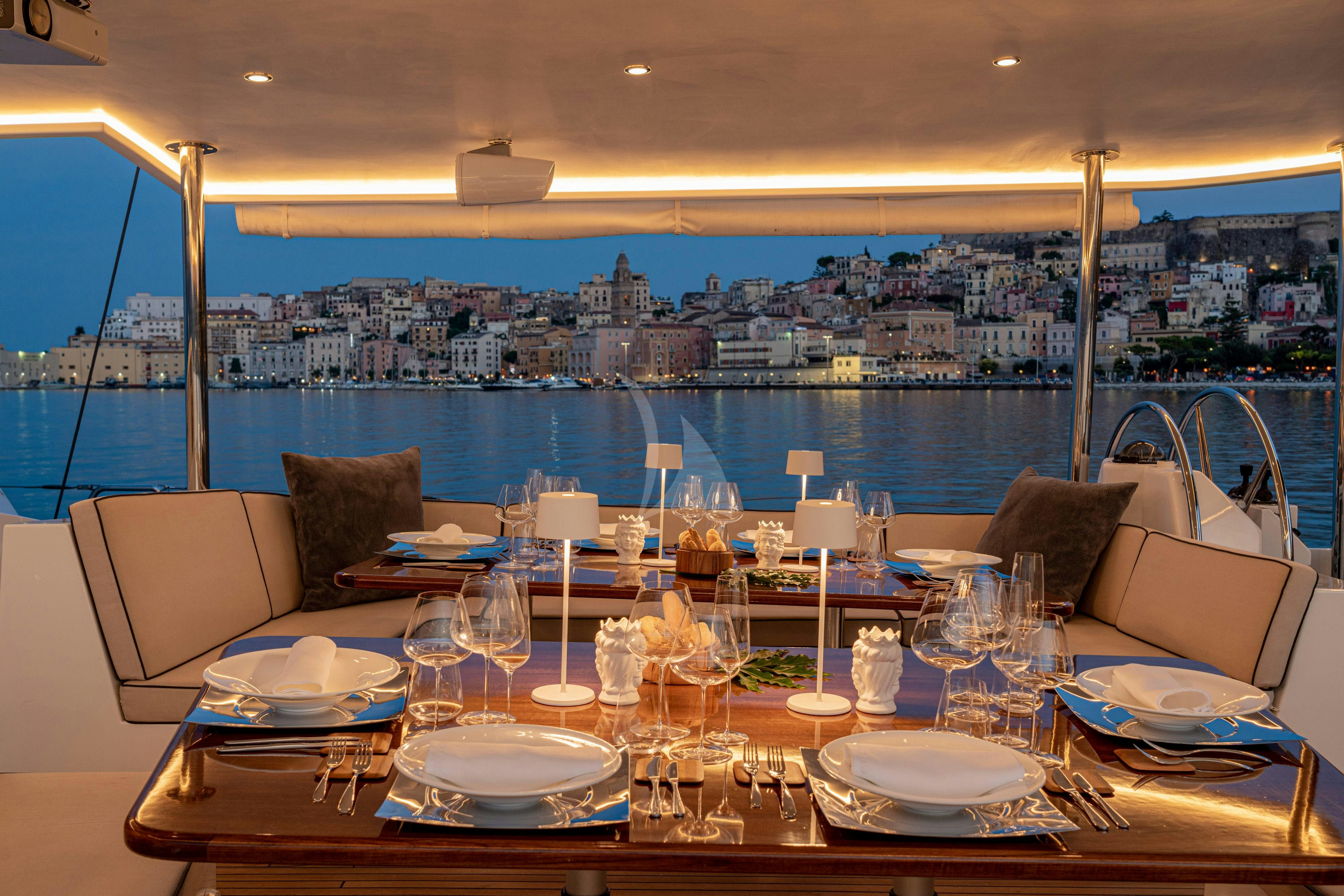 a table with plates and glasses on it aboard ASHLEYROSE110 Yacht for Charter