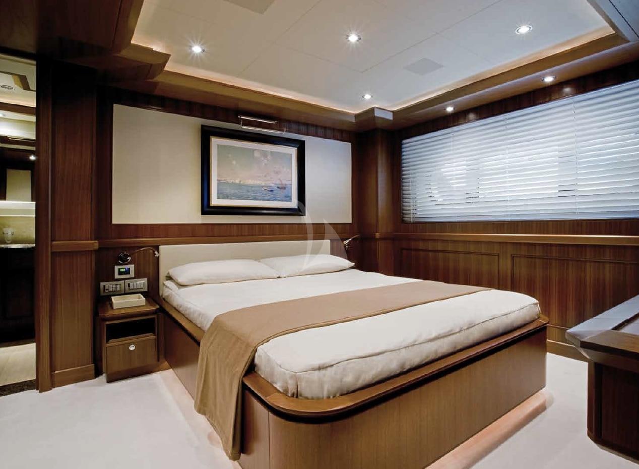 a room with a bed and a table aboard O'LION Yacht for Charter