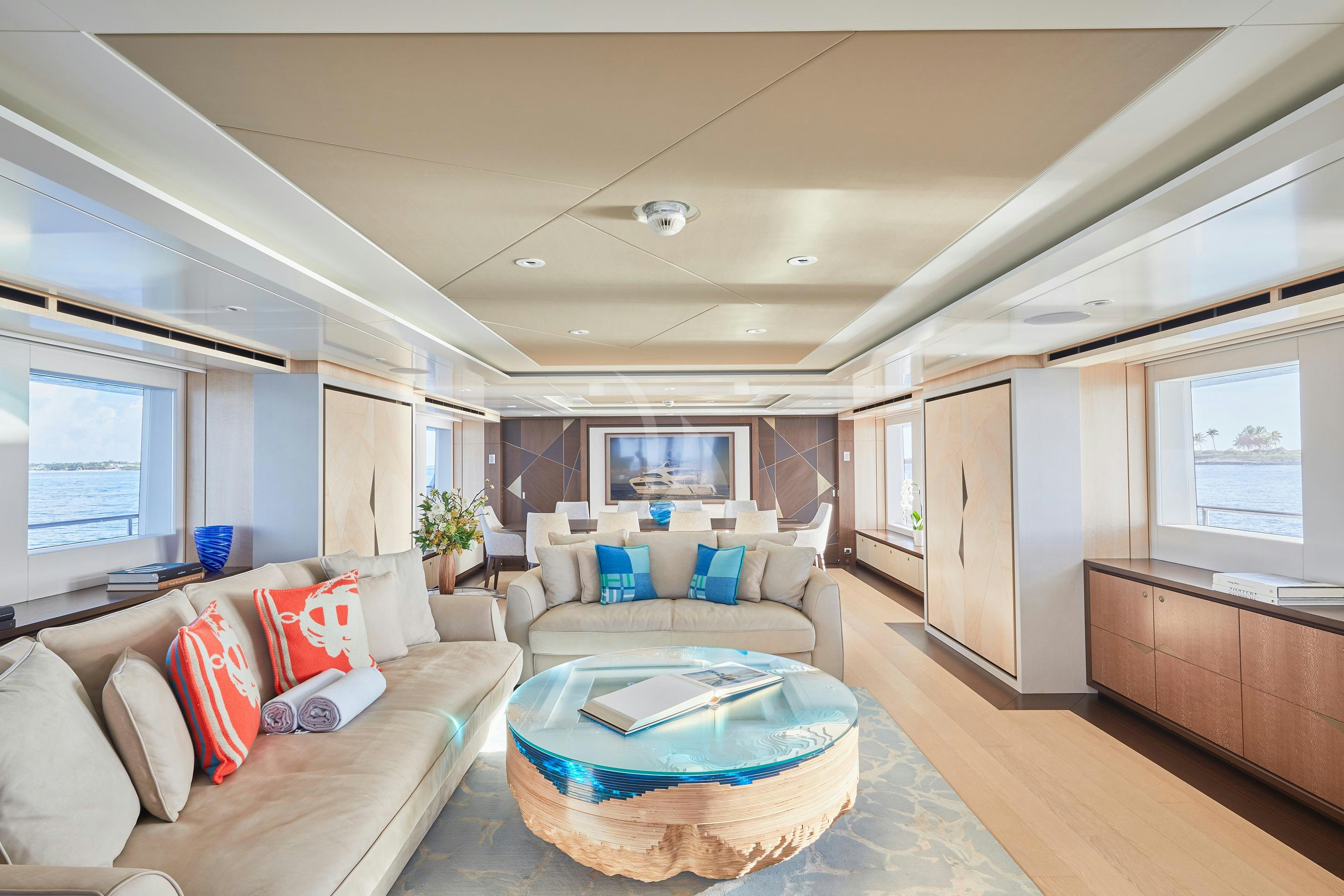 a living room with a large blue round table and a blue couch aboard ARKADIA Yacht for Charter
