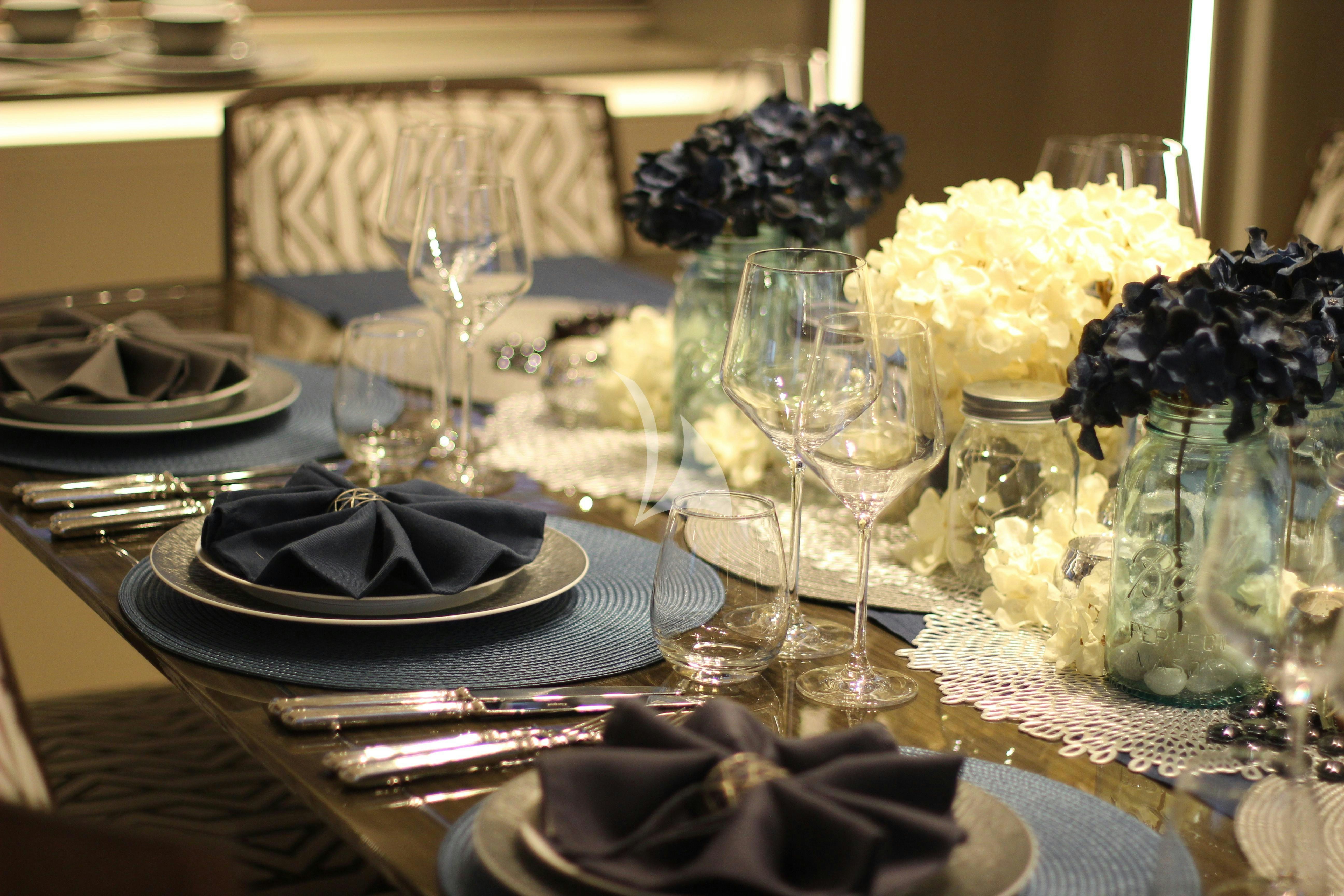 a table with a plate of food and glasses on it aboard THE PEDDLER Yacht for Sale