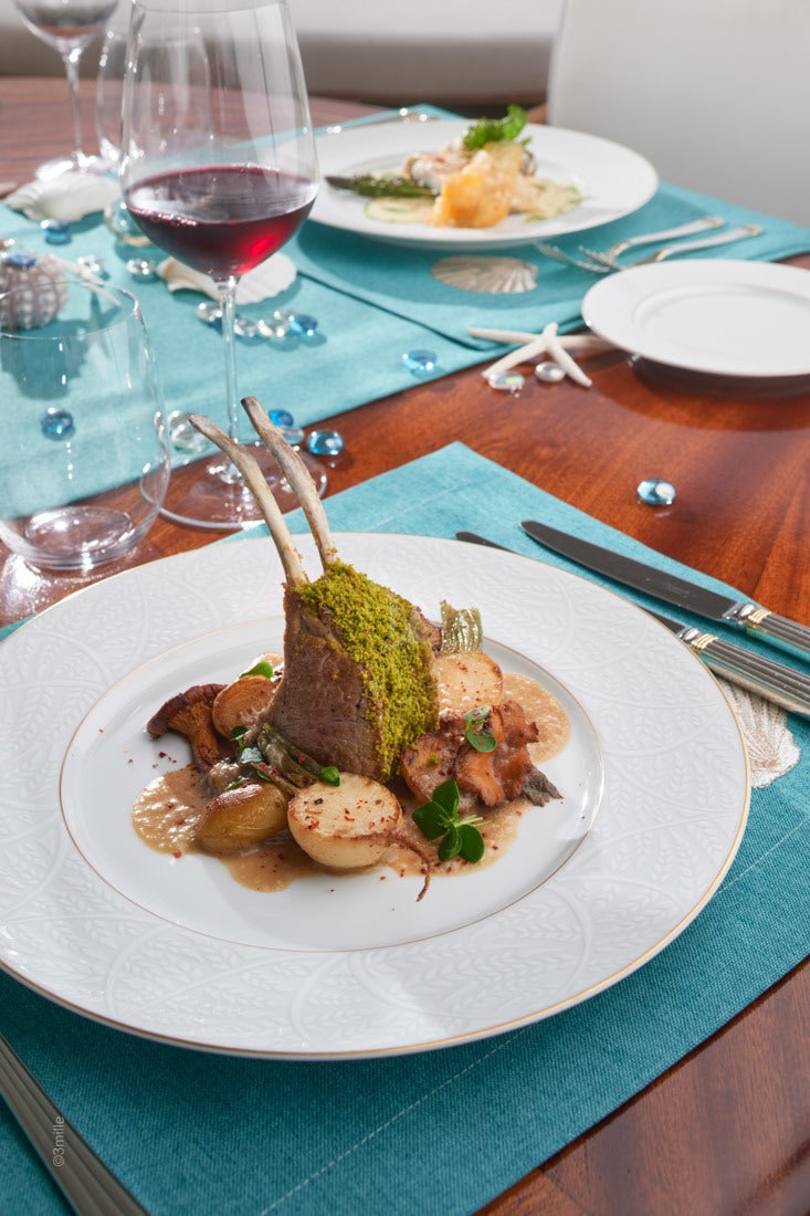 a plate of food and a glass of wine aboard COME PRIMA Yacht for Charter
