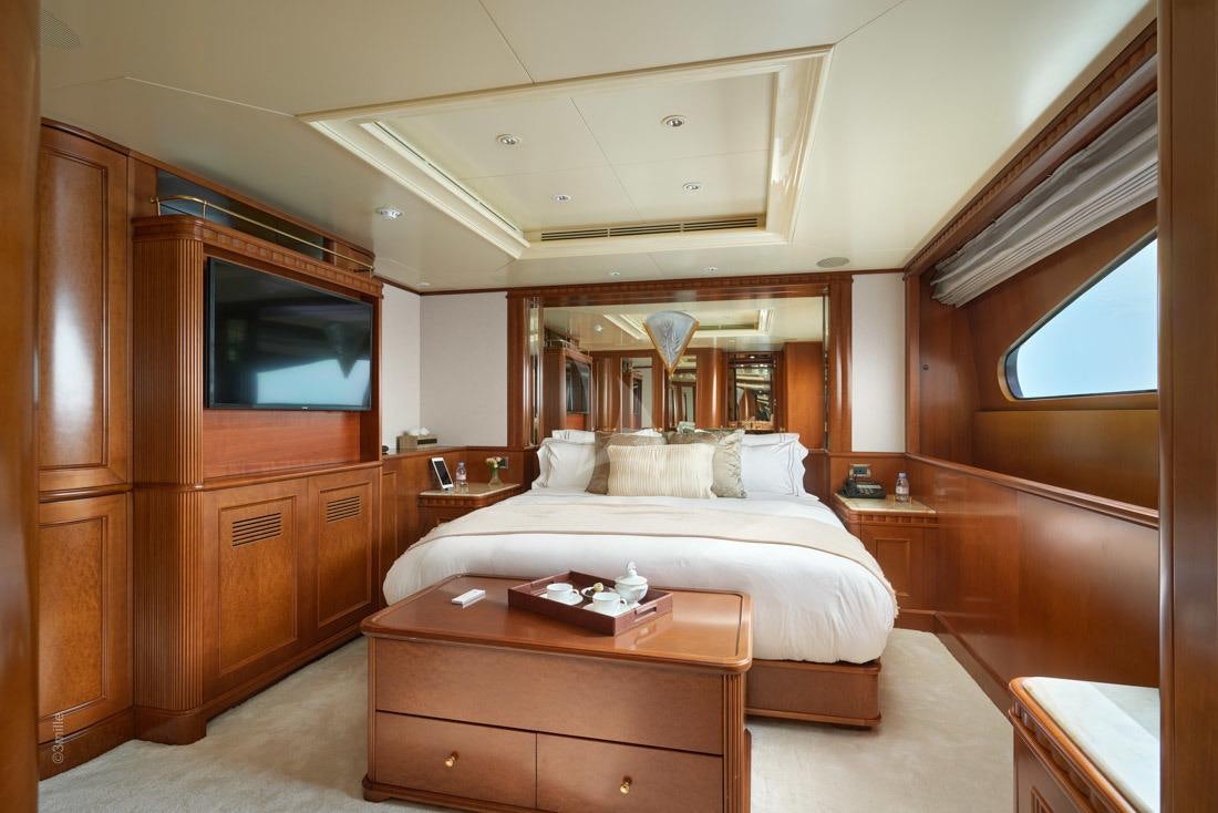 a bedroom with a bed and a television aboard COME PRIMA Yacht for Charter