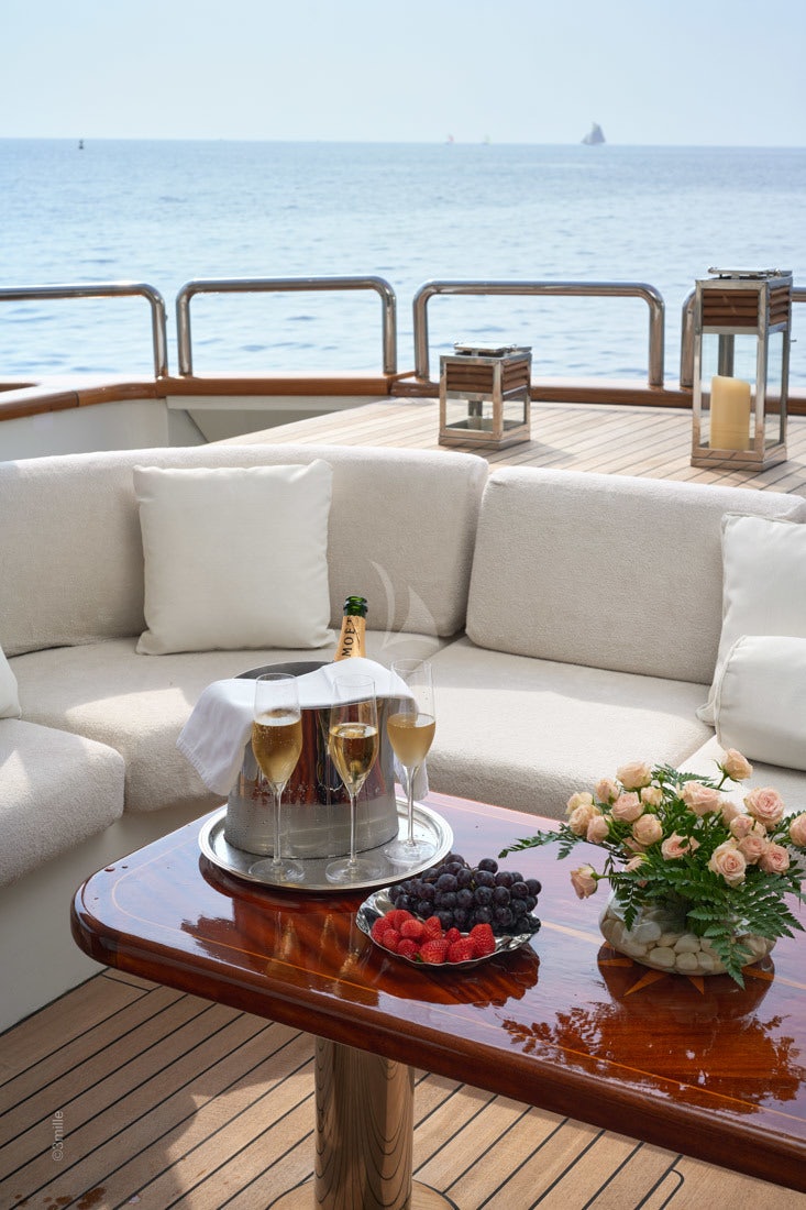 a table with a glass of wine and a bottle of wine on it aboard COME PRIMA Yacht for Charter