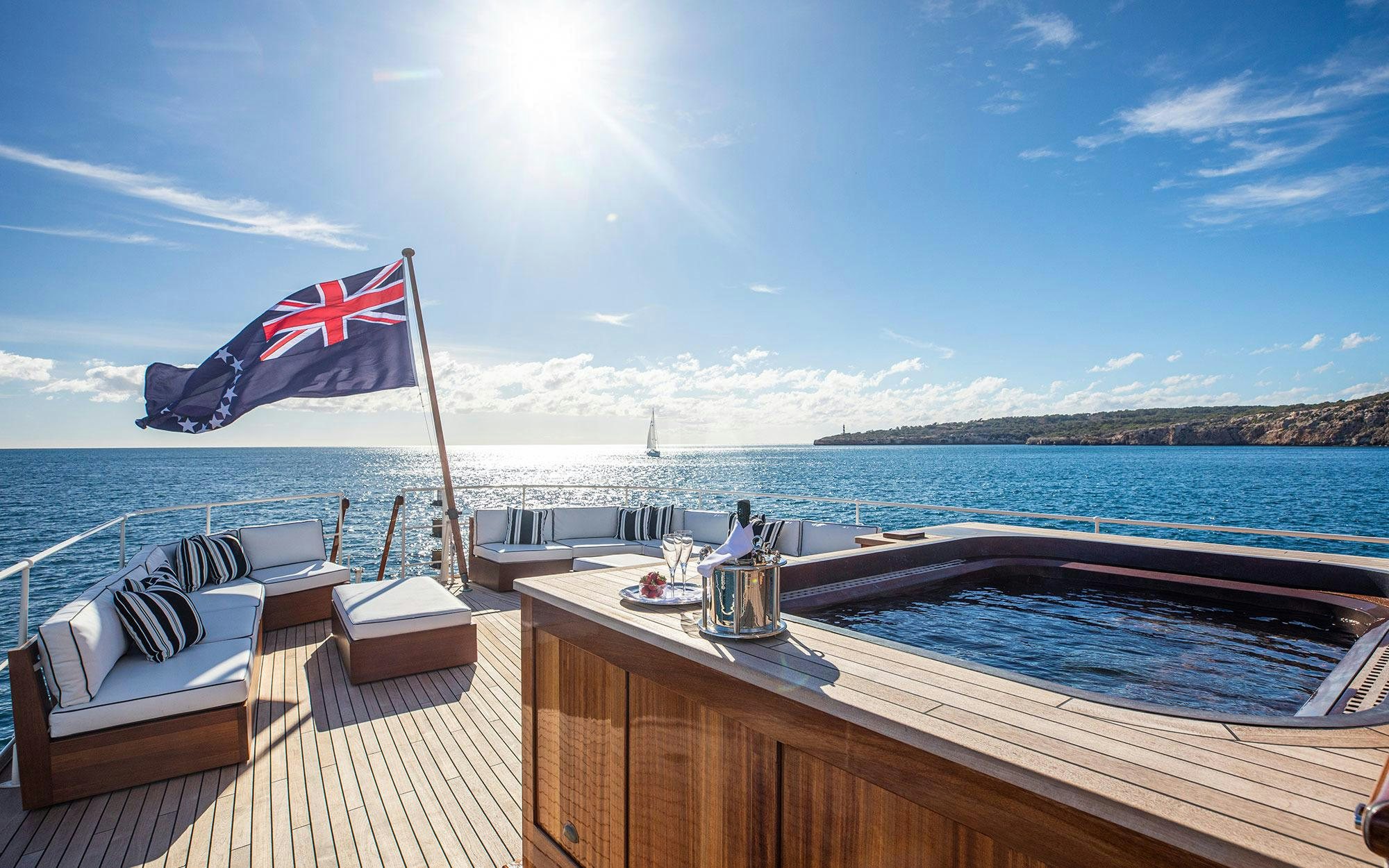 a deck with a flag and a table on it aboard MARALA Yacht for Charter