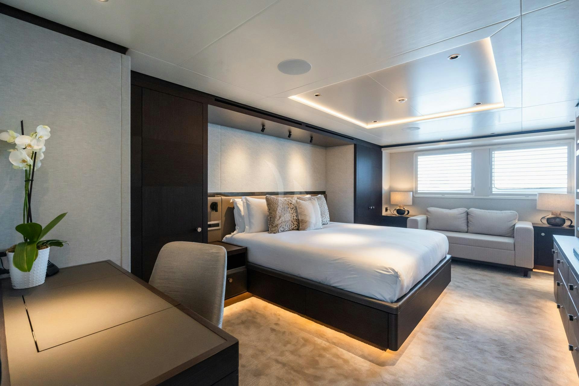 a modern bedroom with a bed and a couch aboard EMERALD Yacht for Charter