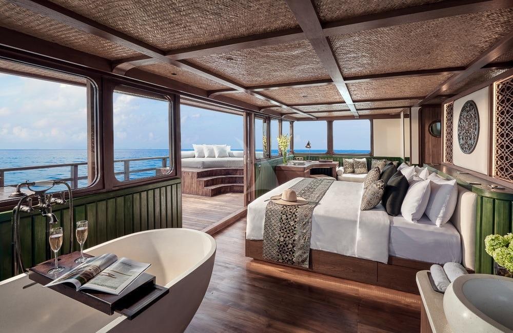 a room with a large bed and a large window aboard SAMSARA SAMUDRA Yacht for Charter