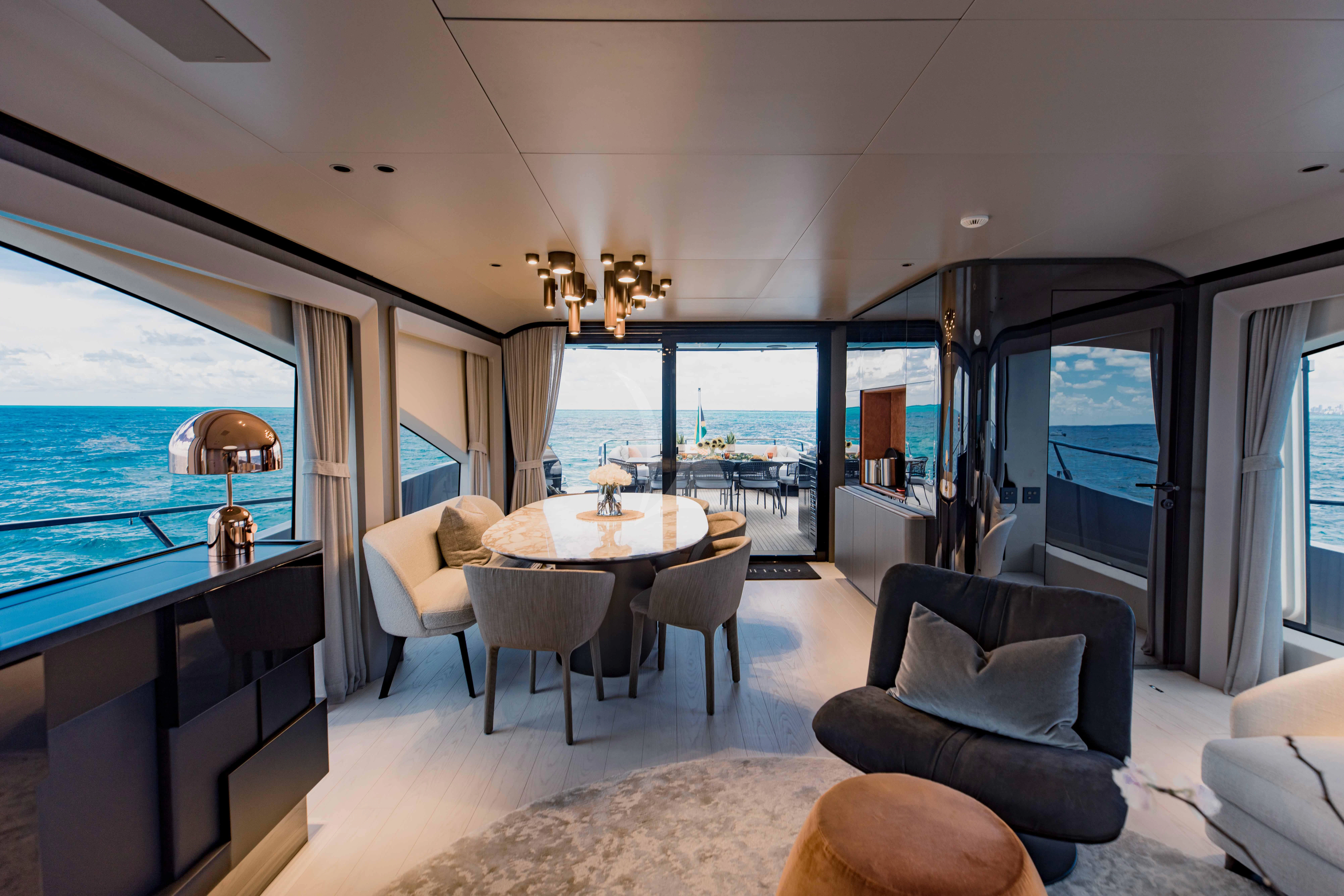 a large living room with a large window aboard OFFLINE Yacht for Charter