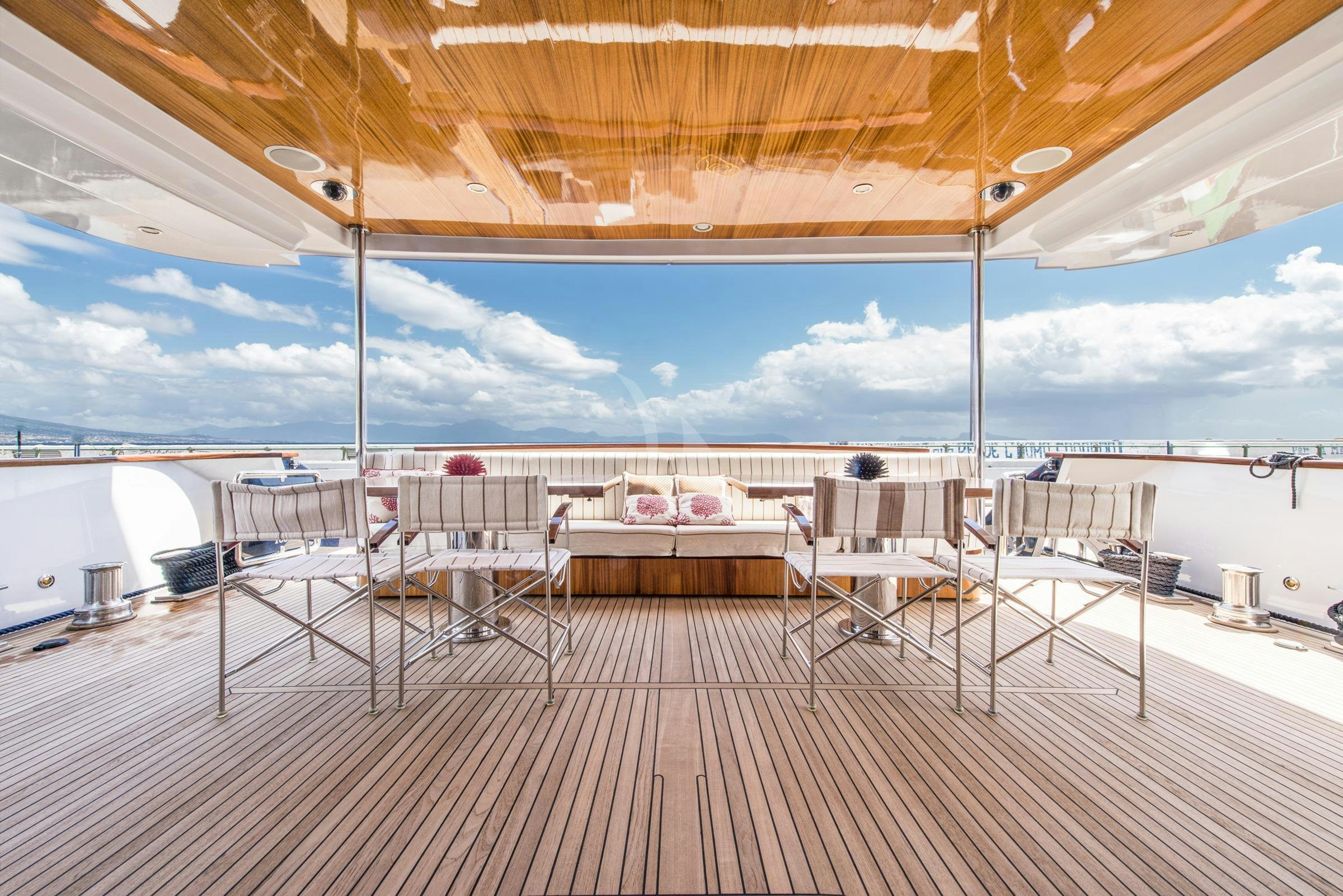 a deck with tables and chairs aboard ANGRA TOO Yacht for Charter